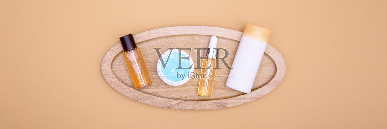 化妆品放在橘色背景的木托盘上。面部、身体和头发护理的概念。照片摄影图片