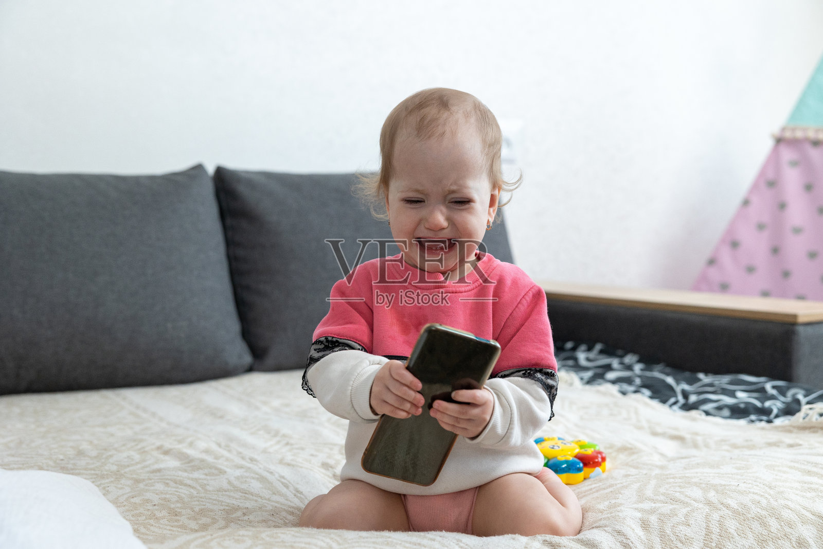 宝宝哭闹是因为乳牙生长时牙床疼痛。照片摄影图片