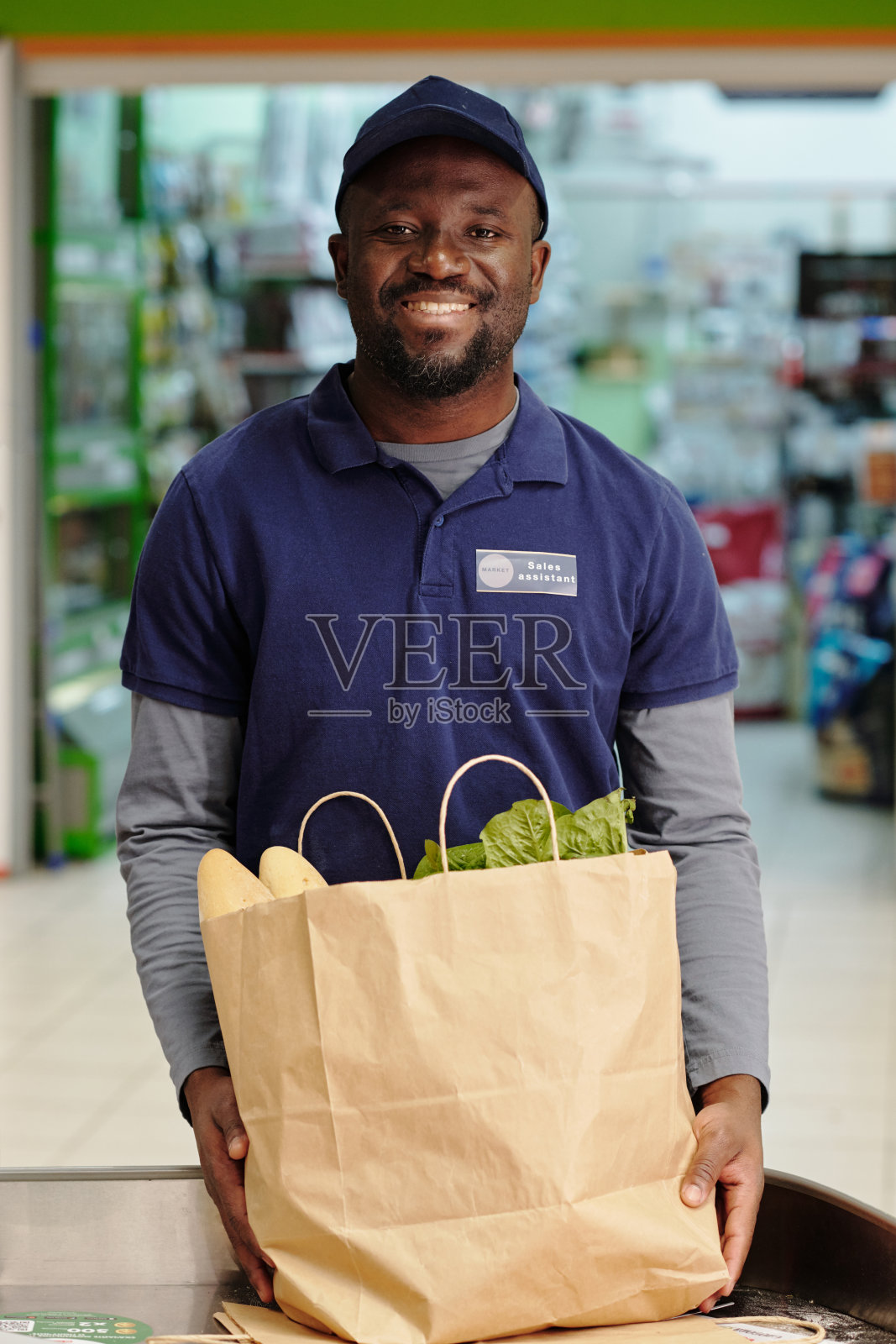 年轻开朗的非裔美国男性销售助理,拿着纸袋照片摄影图片