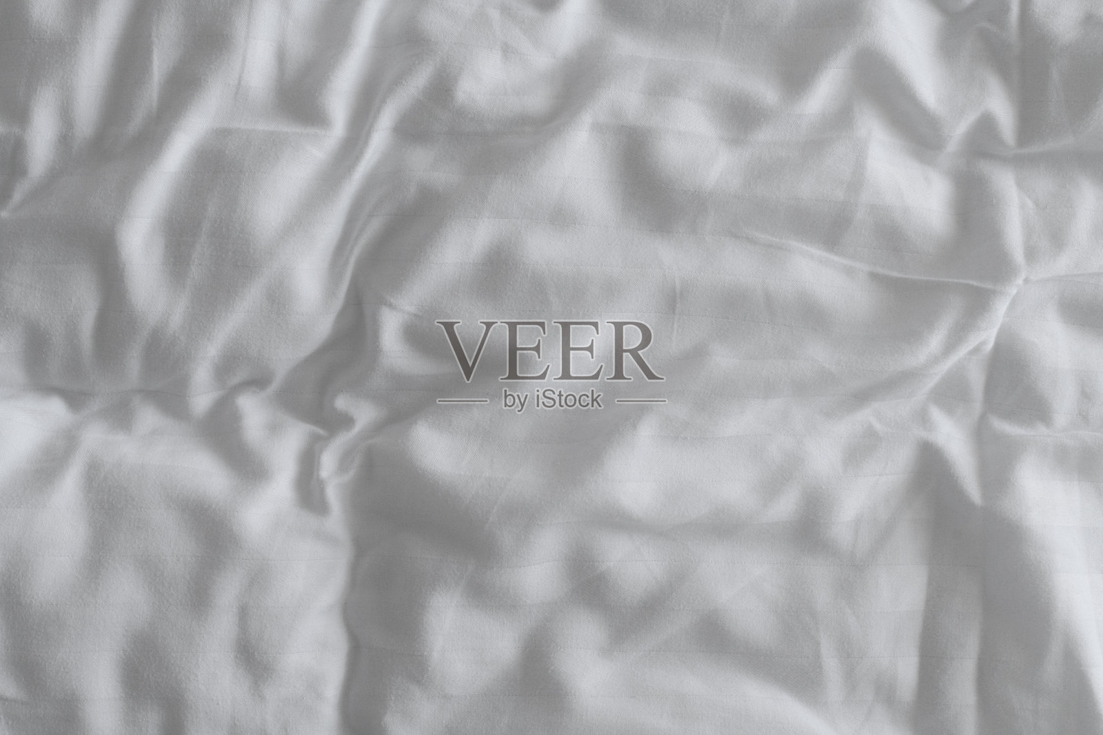 纹理的皱褶白色床单为背景,俯视图照片摄影图片