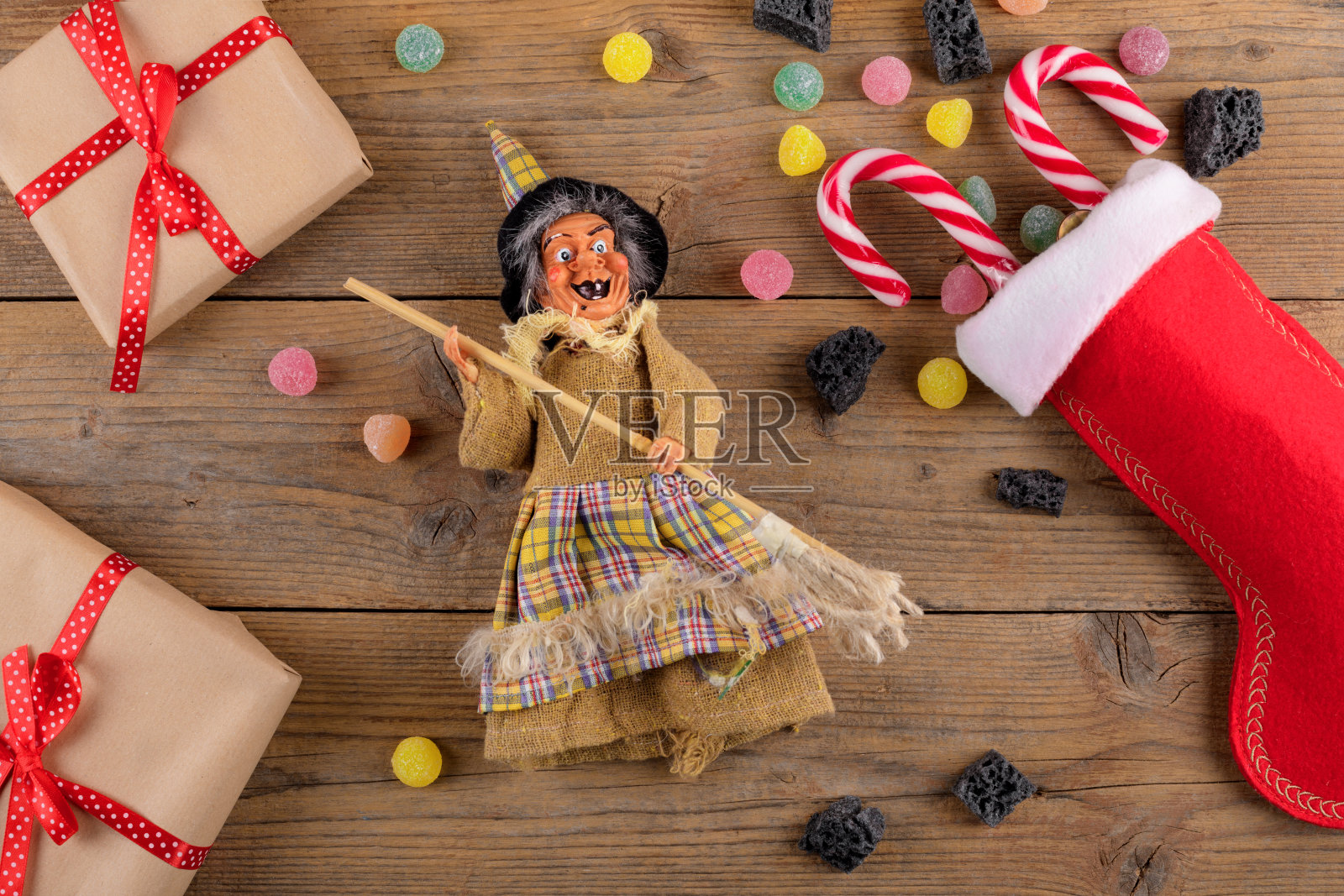 女巫贝法娜和红色袜子与甜煤和糖果的乡村木制背景。意大利主显节的传统照片摄影图片