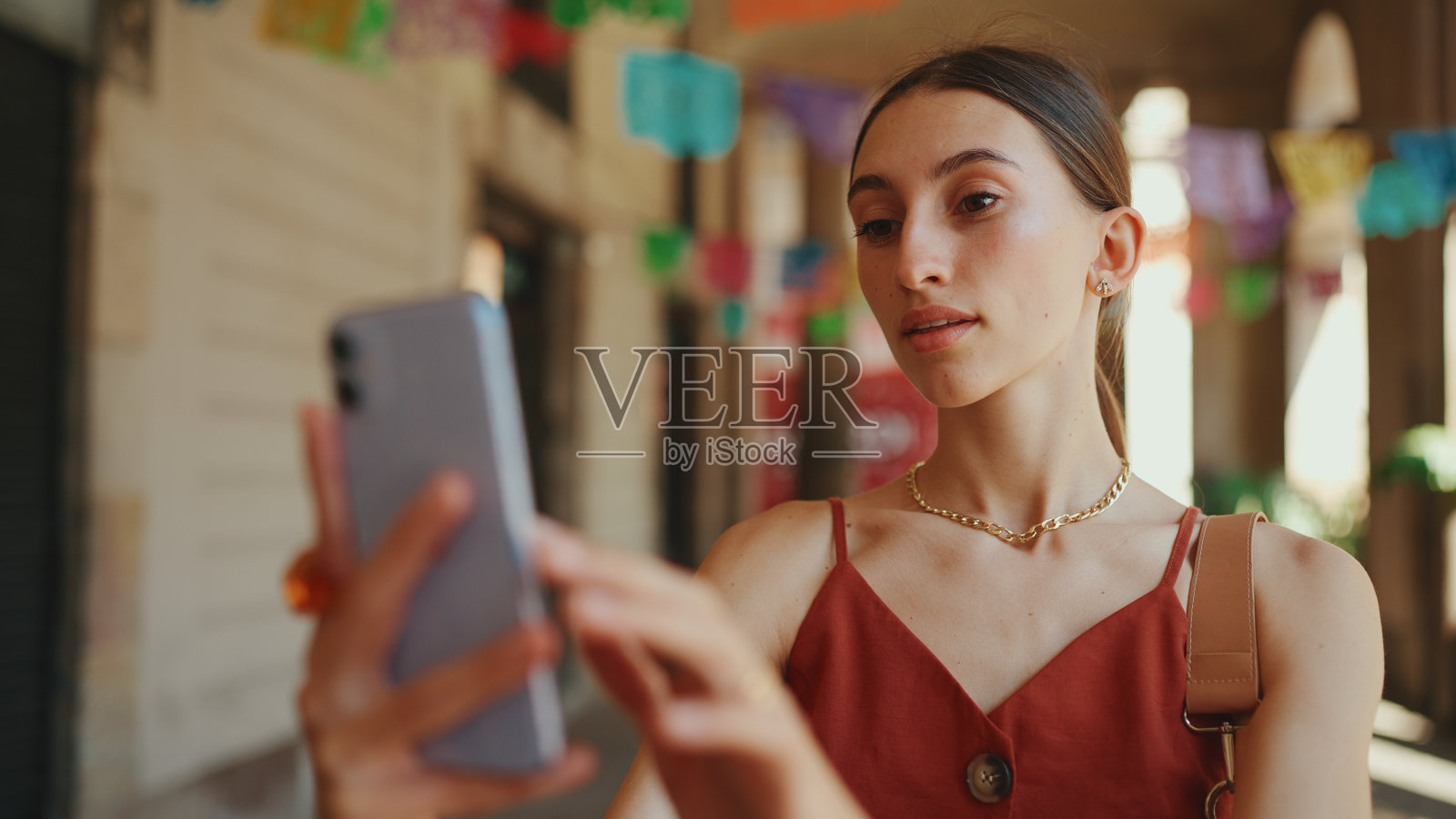 迷失的年轻女子在城市背景下拍了一张自拍,在街上视频通话。微笑的女孩使用社交媒体,流媒体服务照片摄影图片