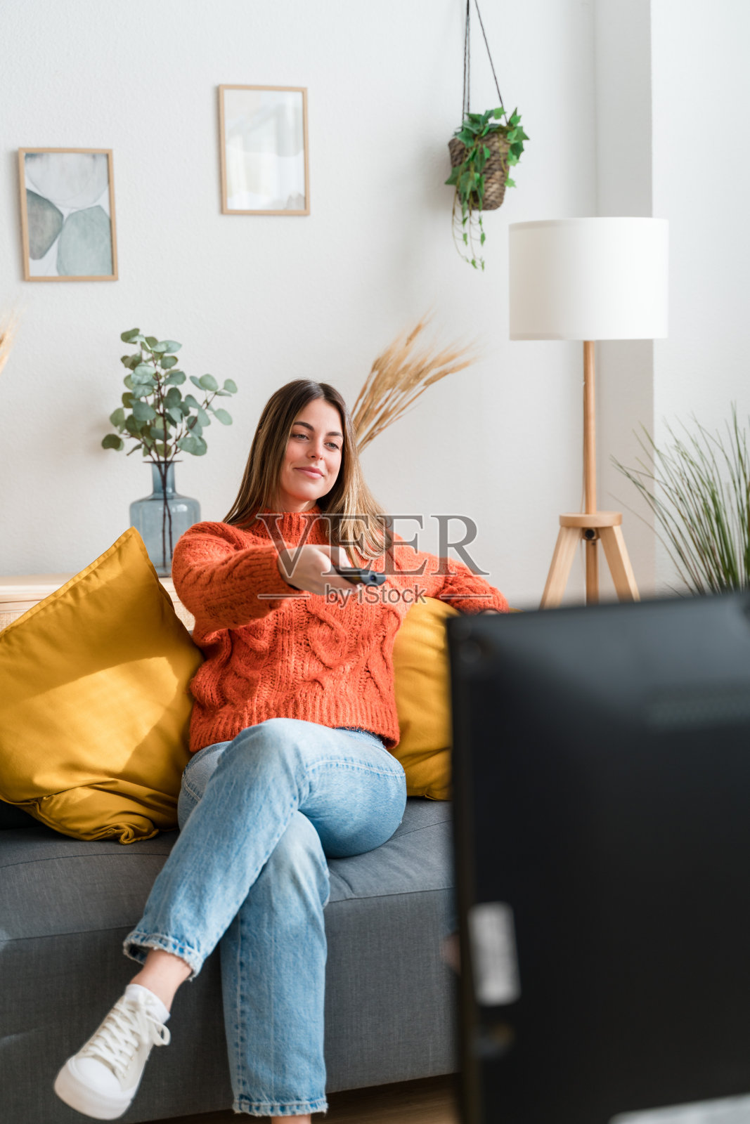 年轻女子在客厅看电视照片摄影图片