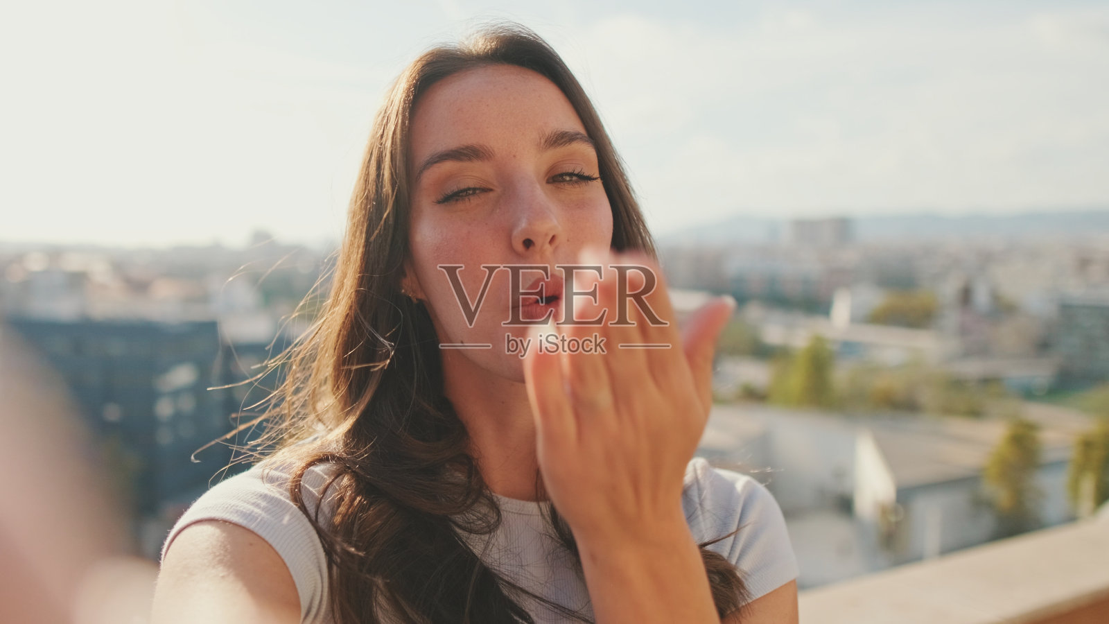 年轻女子站在阳台上自拍手和平标志的特写照片摄影图片