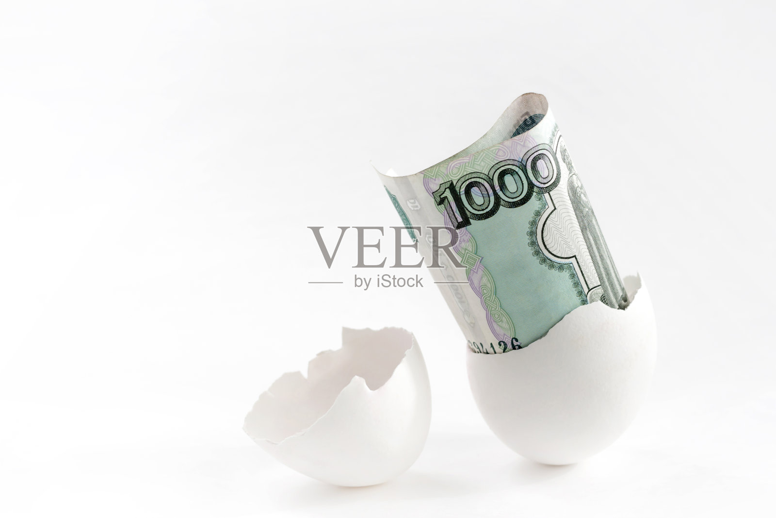 白色背景上的蛋壳和1000俄罗斯卢布。概念有利可图的生意,惊喜,财富,运气。照片摄影图片