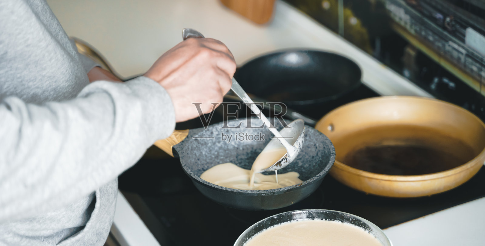 做很多美味的大煎饼,很多平底锅,油,煎饼面团。俄罗斯传统的民族节日冬季马列尼察节日周、忏悔节。伙计,厨师爸爸。家庭度假照片摄影图片