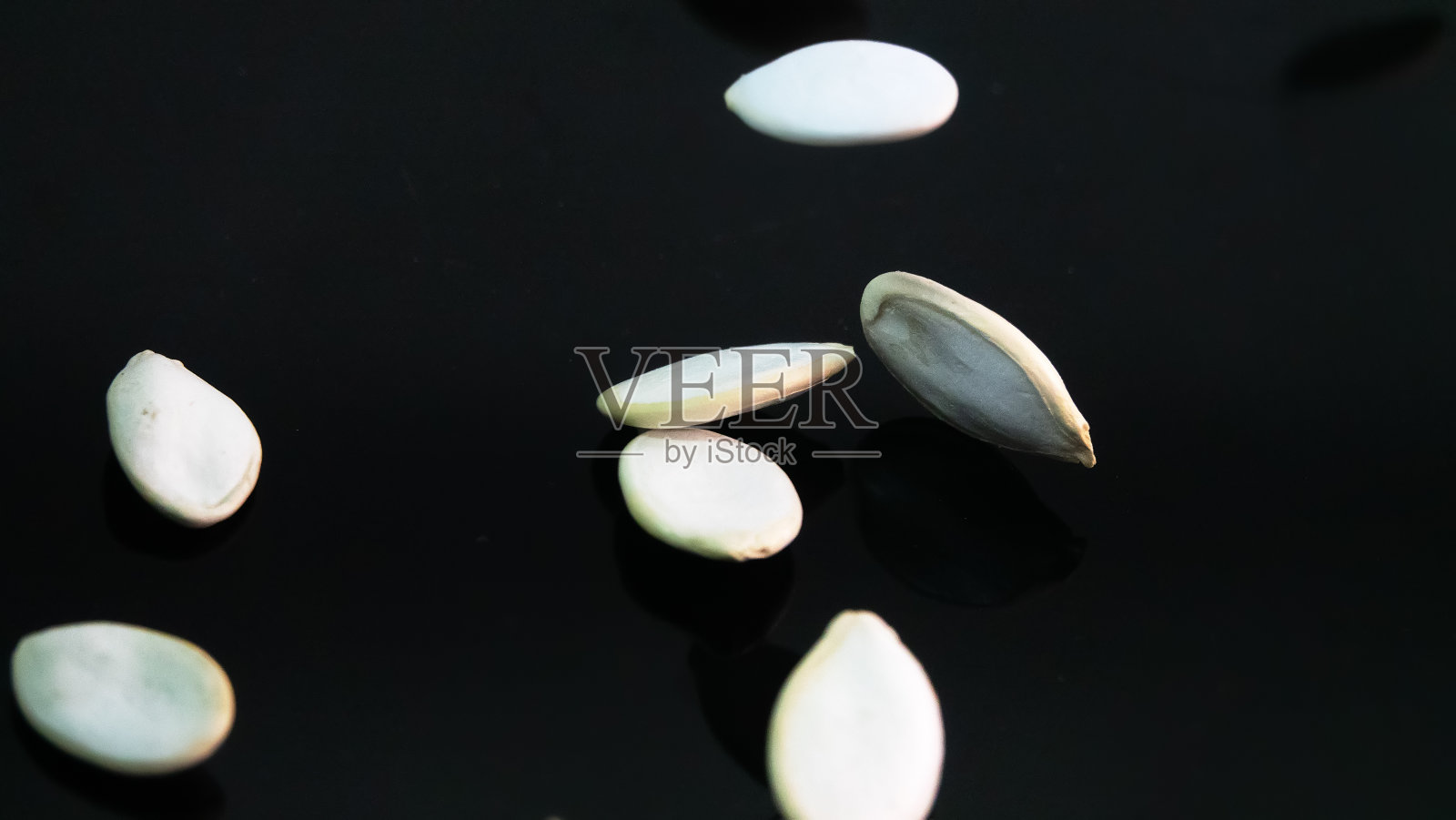 黑漆盘上的南瓜籽照片摄影图片