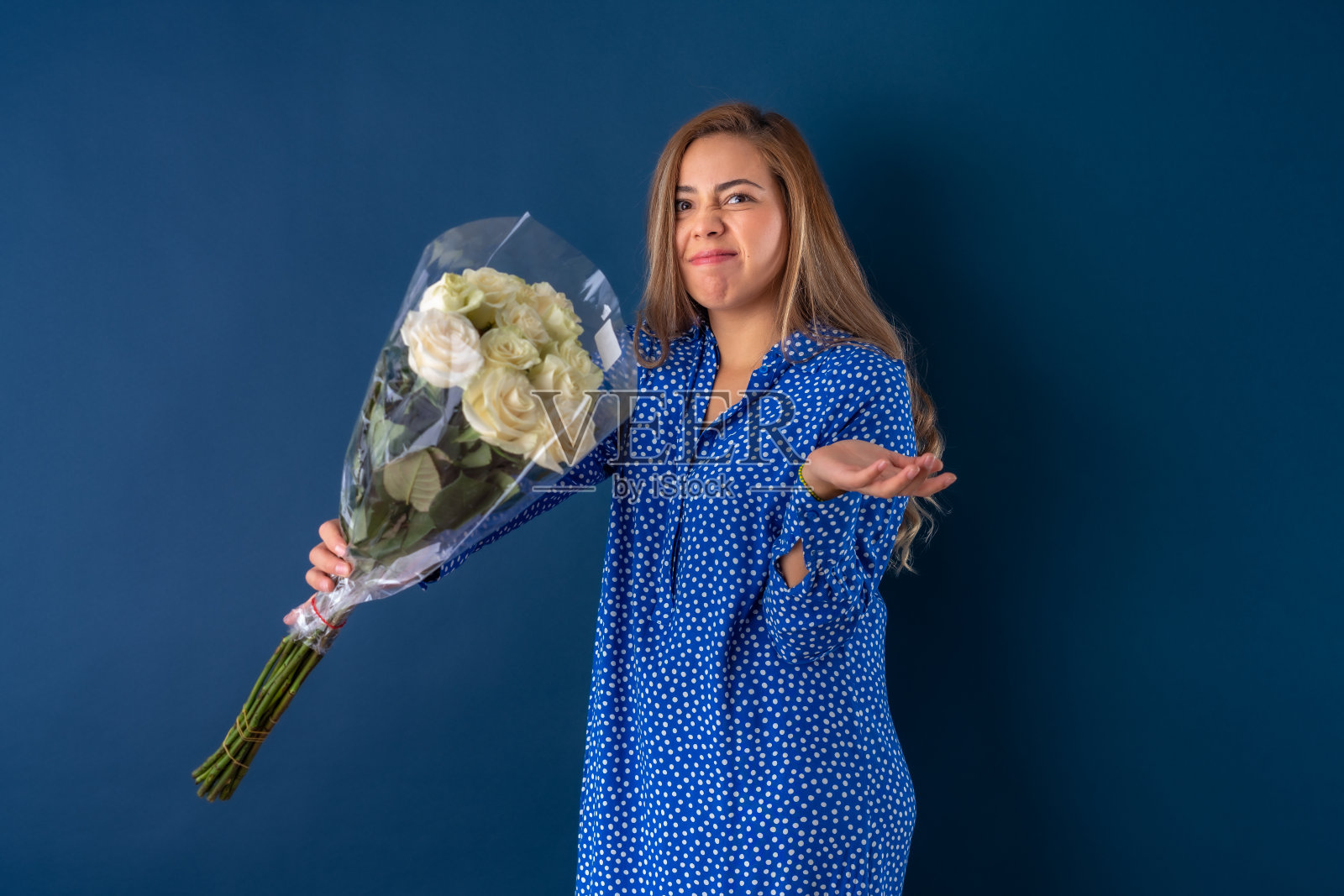 痛苦地拿着白玫瑰的年轻女子照片摄影图片