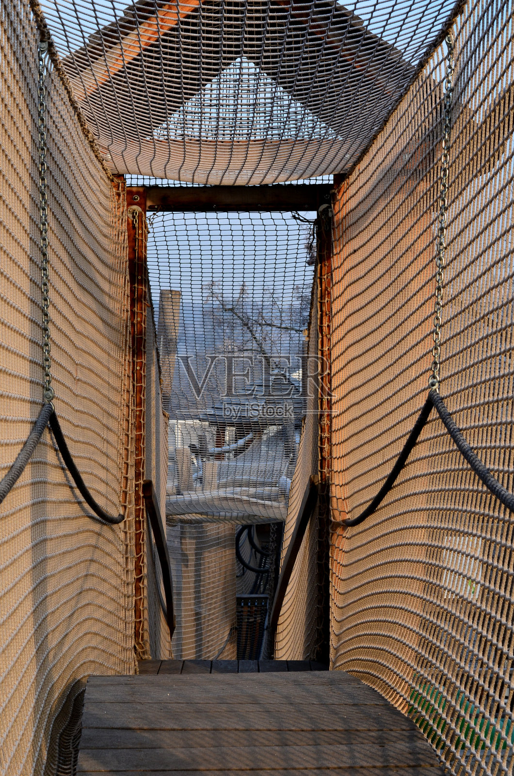 用绳子做成的网状隧道。访客的孩子,爬过迷宫。不锈钢滑轨。城市parl mebo学校庭院木制景点城堡照片摄影图片