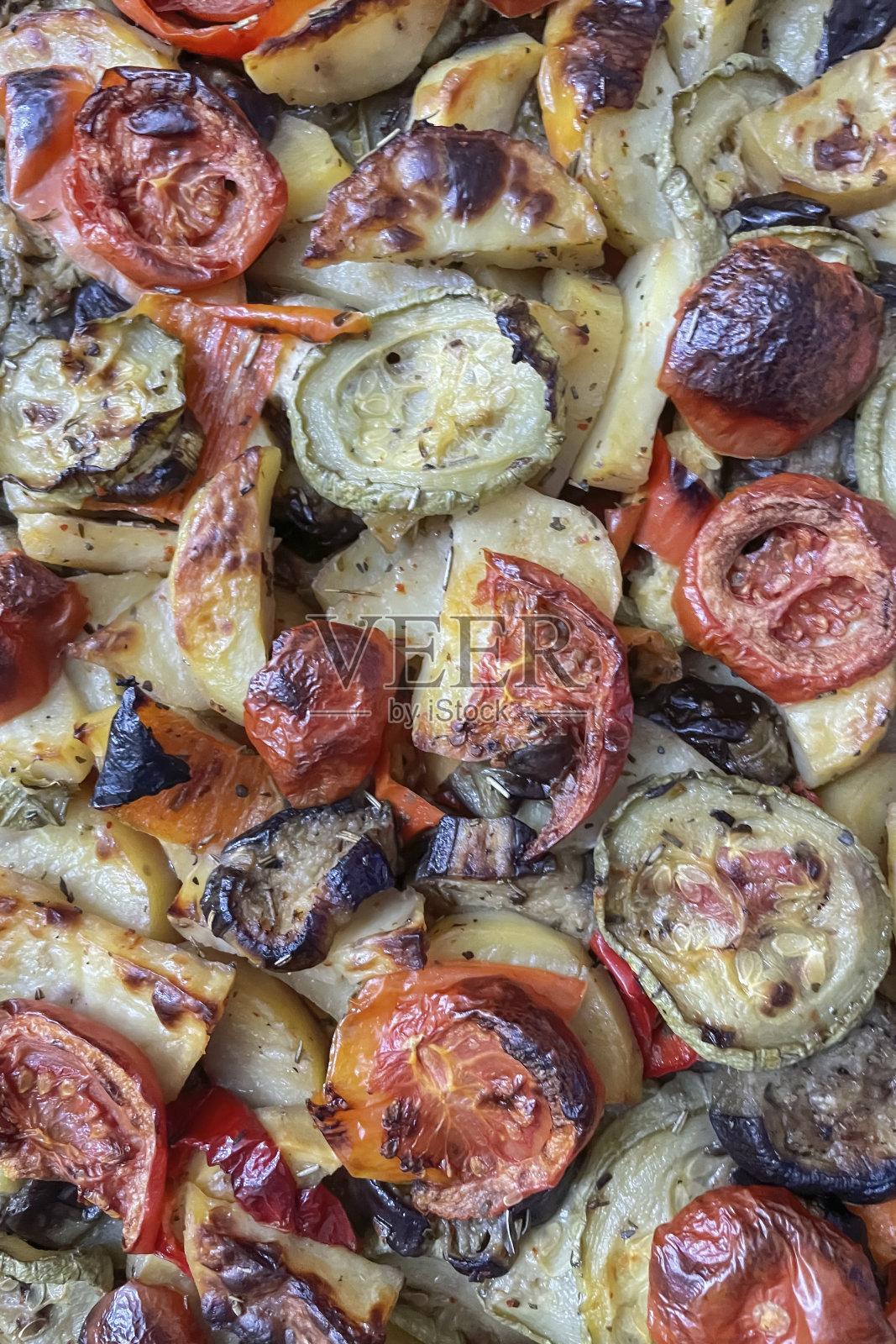 近距离的烤土豆与茄子,番茄和洋葱。照片摄影图片