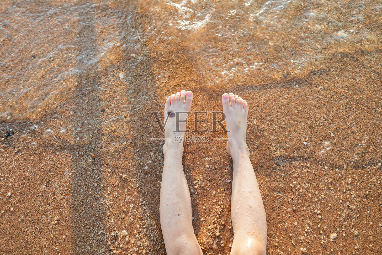 清晨,蹒跚学步的女孩坐在海滩上照片摄影图片