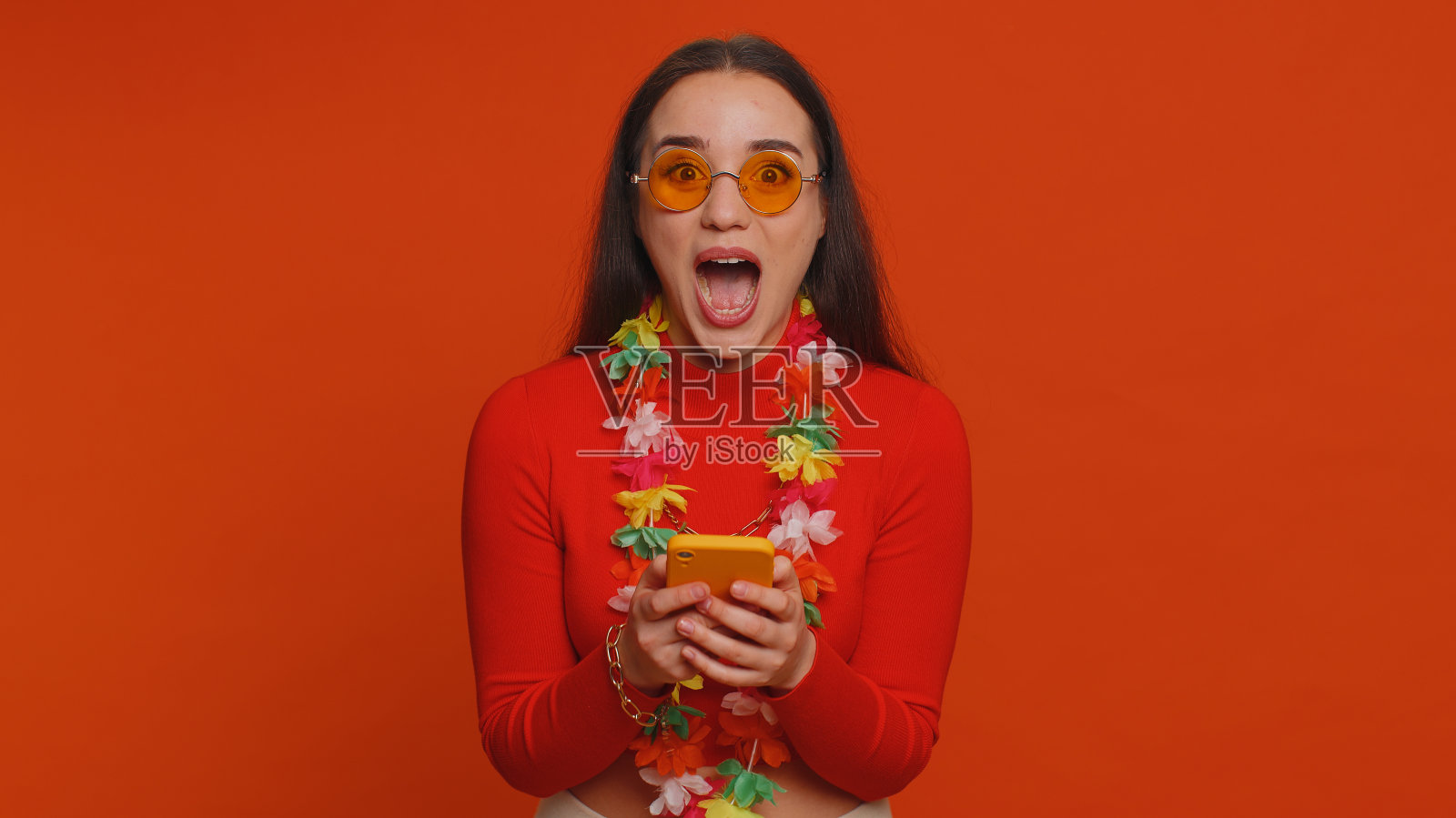 快乐的女游客在智能手机上庆祝赢得度假胜地度假门票照片摄影图片