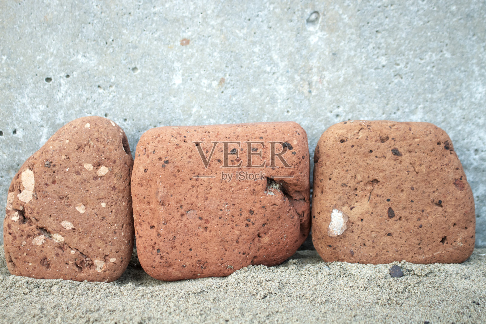 沙滩上有三颗橙色的石头照片摄影图片