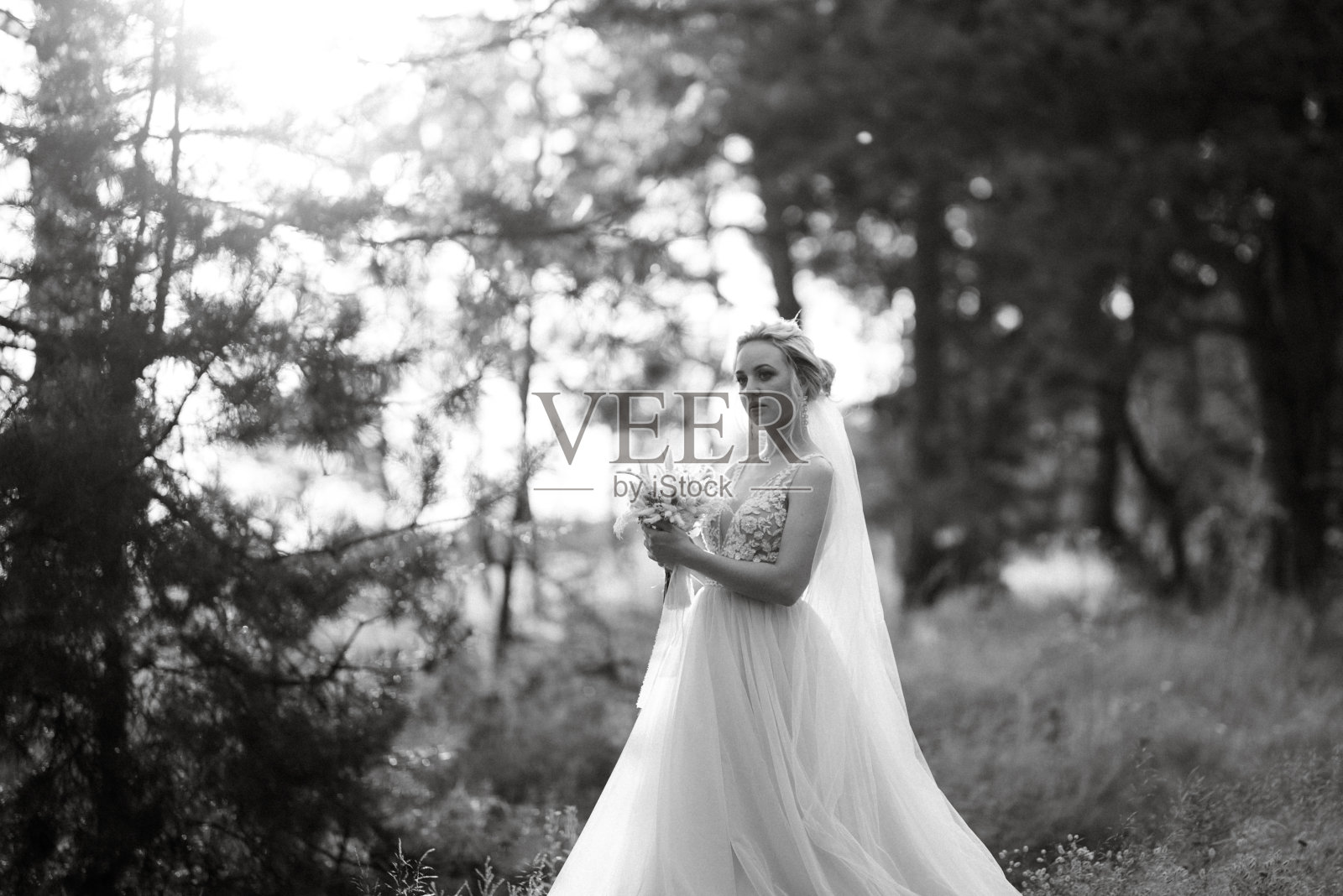 金发新娘,手捧花束在森林里照片摄影图片