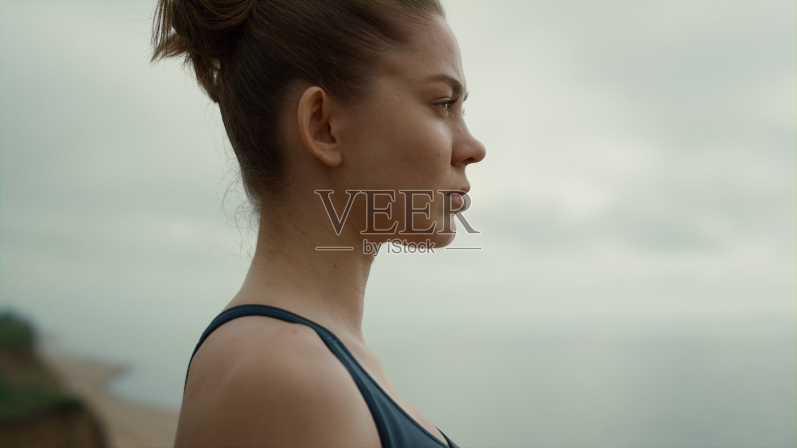 女运动员向前看站在海滩特写。女孩做呼吸练习照片摄影图片