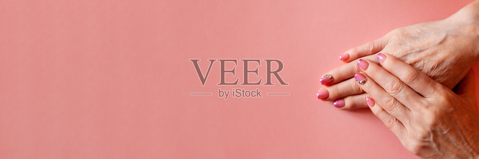 成人修指甲。一个成年女子的手与一个美丽的美甲在淡粉色的背景。手部修剪自然,清洁成人肌肤。高分辨率照片摄影图片