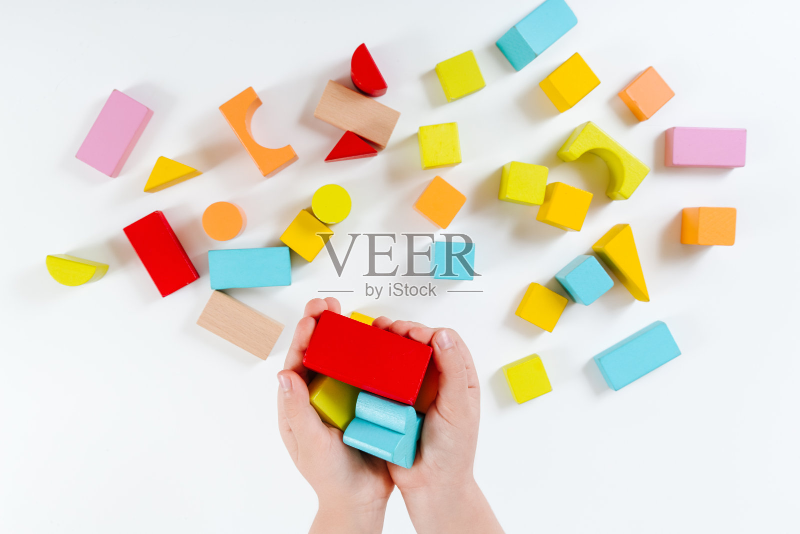 孩子的手在玩五颜六色的木砖。木制玩具。发展和学习的理念。白色背景。平的。天然材料。照片摄影图片