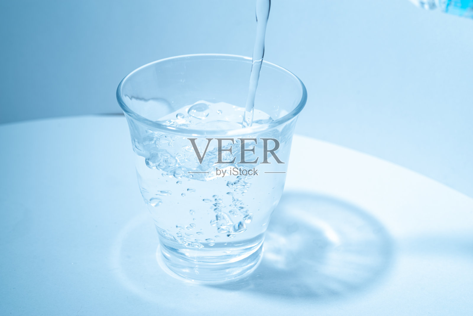 把水倒进玻璃杯里照片摄影图片