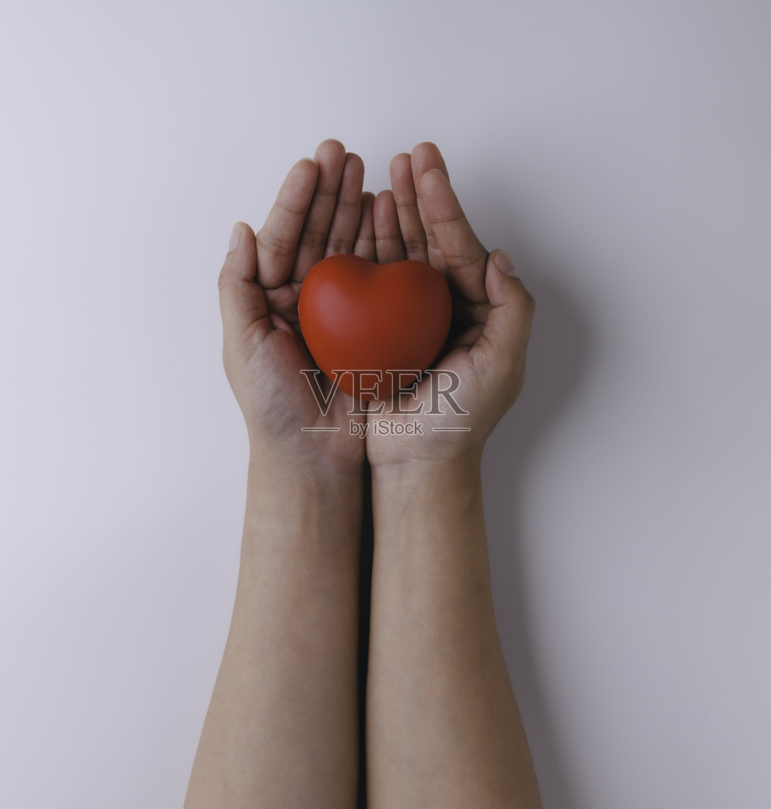 女性手拿红心白底,俯视图与文字空间。捐赠的概念。照片摄影图片