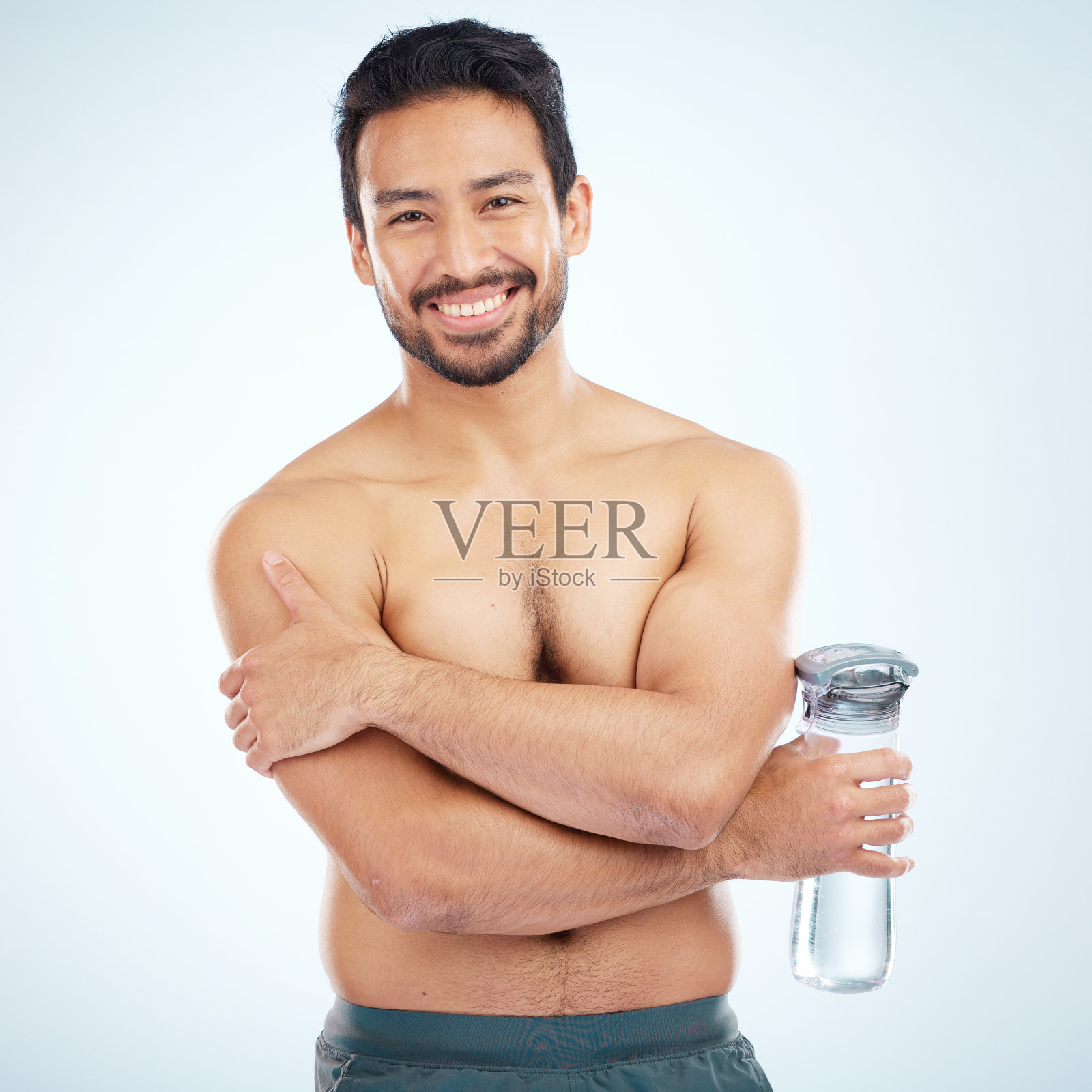 男人,健身和水瓶在工作室肖像微笑,健康或保健运动由蓝色背景。模特,赤膊或水自我护理,自爱或身体积极的工作室背景照片摄影图片