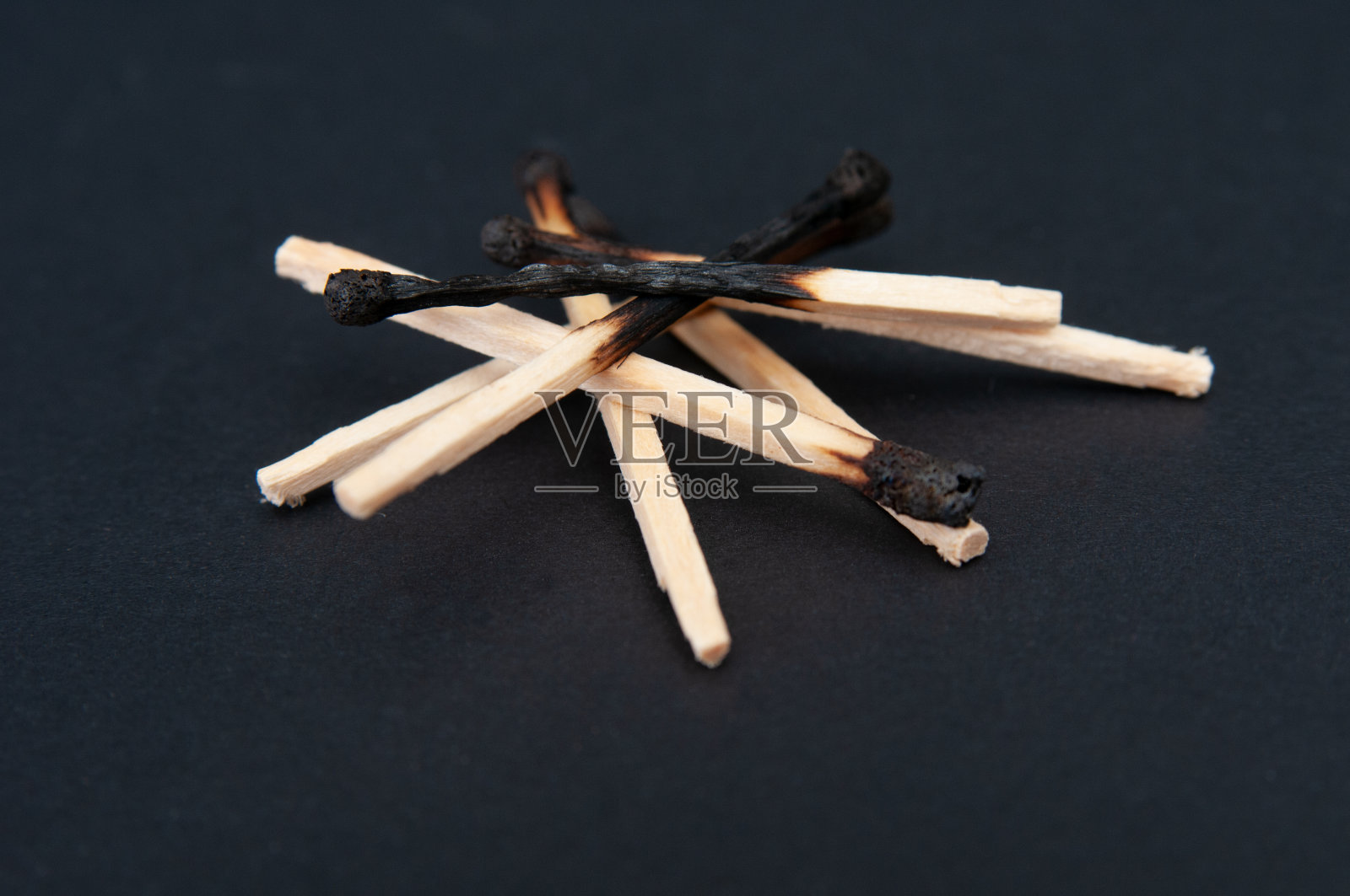 燃烧的火柴棒在黑色背景上照片摄影图片