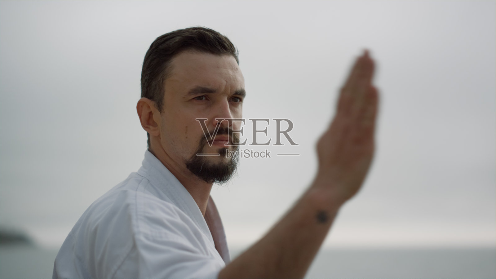 运动的男子在阴沉的日子里锻炼。正在练习武术的战士。照片摄影图片