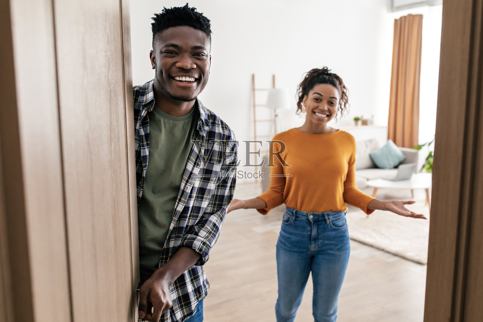 快乐的黑人配偶开门迎接你在家里摆姿势照片摄影图片