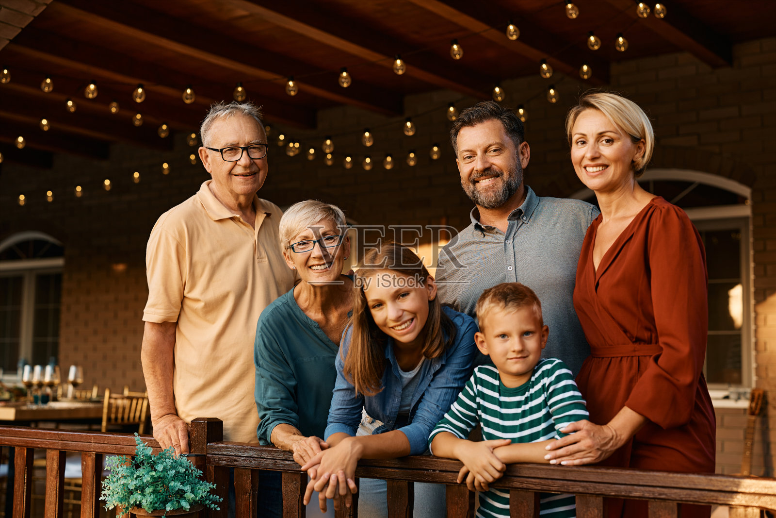 幸福的大家庭在阳台上看着相机的肖像。照片摄影图片