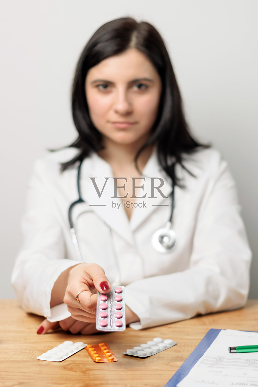 身穿白大褂的女医生手持治疗水泡的药丸,专注于前景、保健和用药理念照片摄影图片