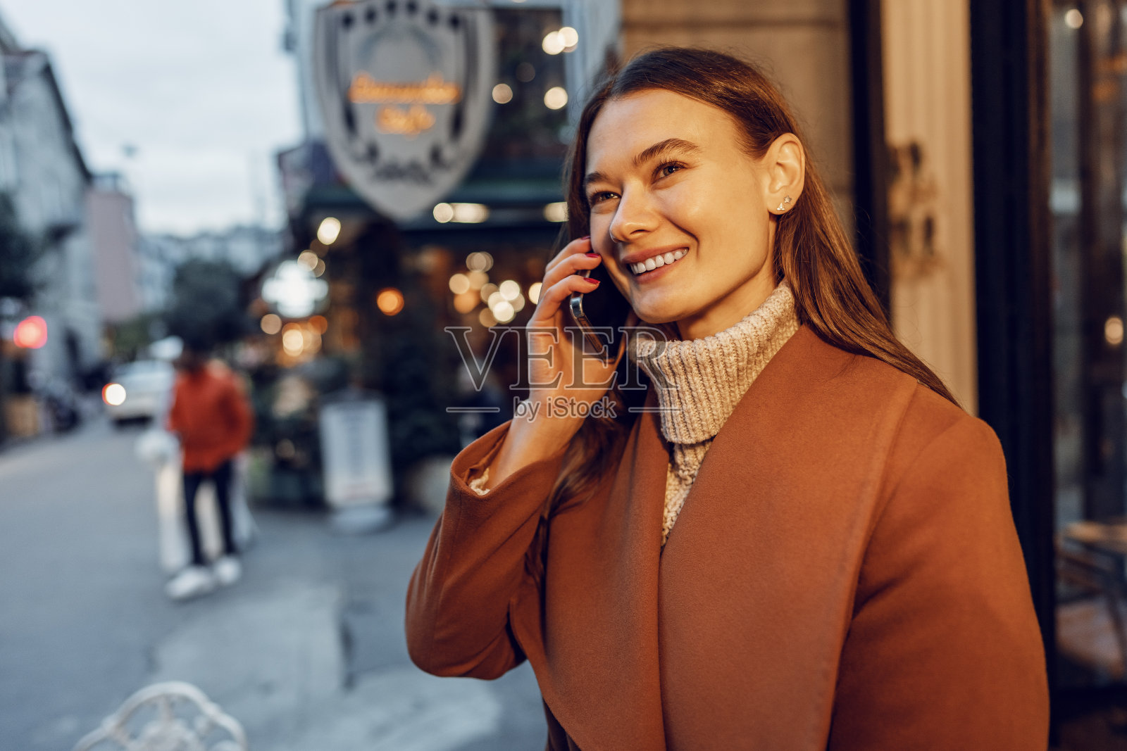 年轻快乐的女人在街上打电话照片摄影图片