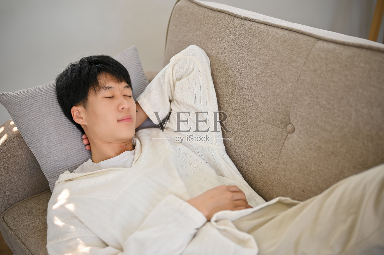 俯视图一个放松和冷静的年轻亚洲人穿着舒适的衣服睡在沙发上照片摄影图片