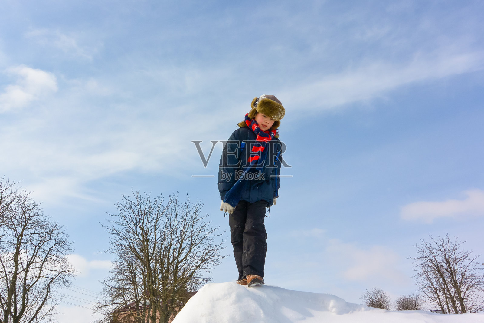 男孩在下雪的冬季公园玩得很开心照片摄影图片