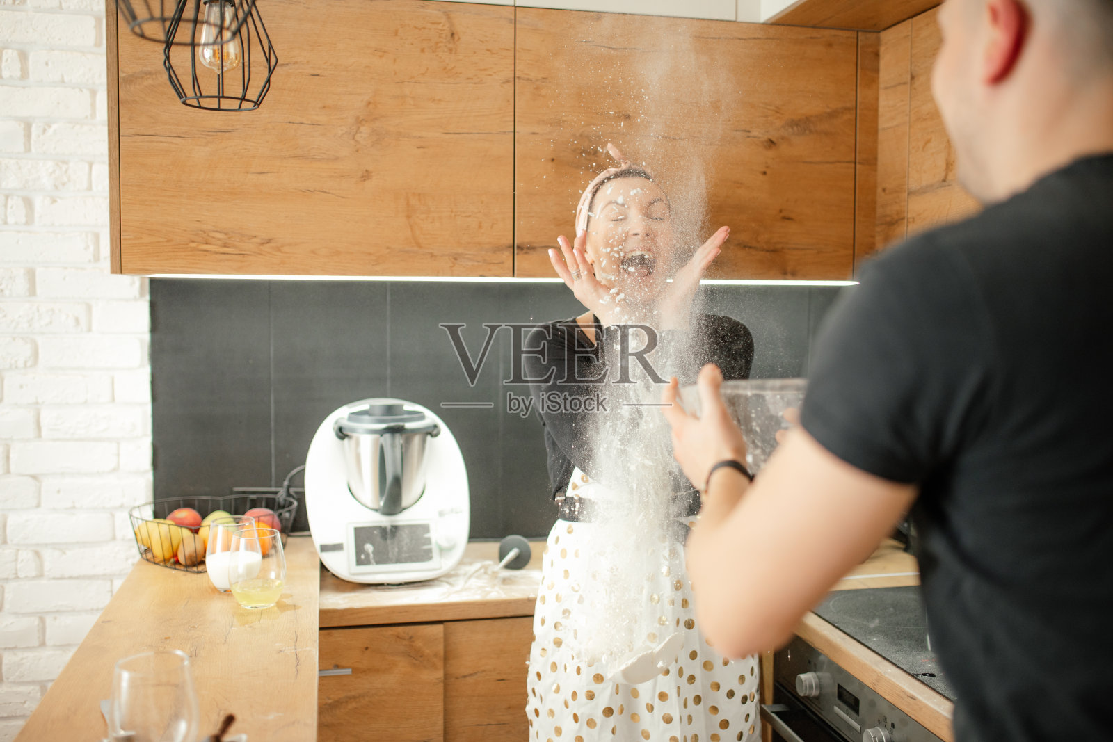 俏皮的,淘气的,积极浪漫的情侣,男人和女人在围裙和头巾扔面粉给对方照片摄影图片