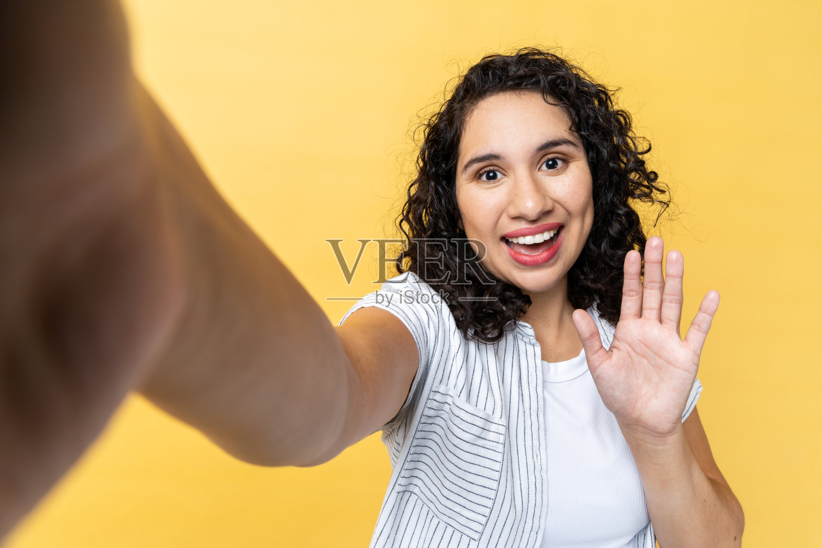 微笑友善的女人拍摄POV照片,挥手致意照片摄影图片