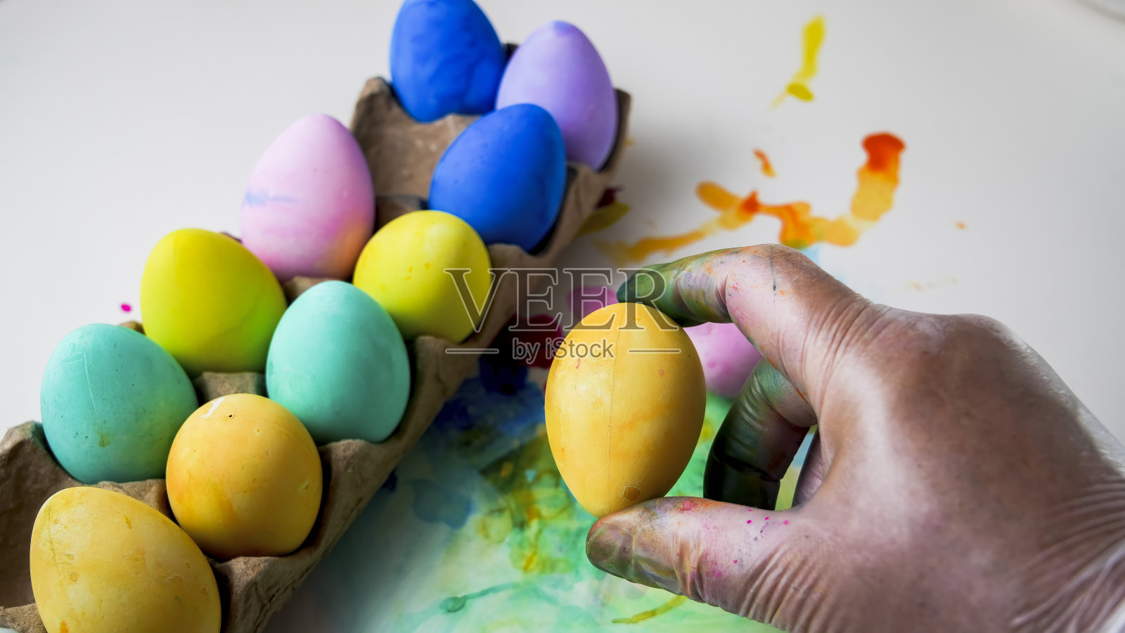 彩色背景与手握复活节彩蛋照片摄影图片