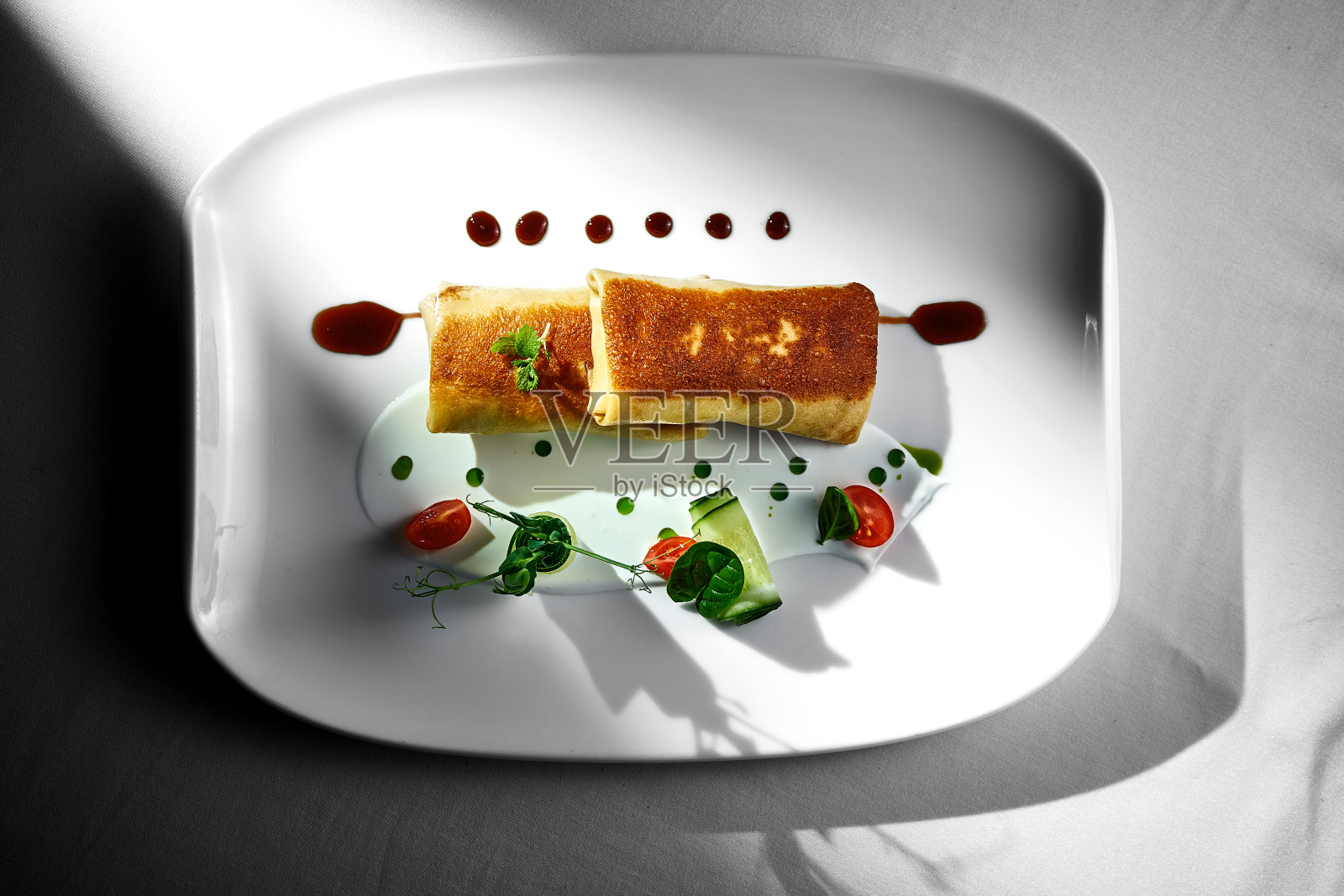 盛有肉末和酱汁的薄煎饼。白色桌布背景。乌克兰小薄饼。照片摄影图片