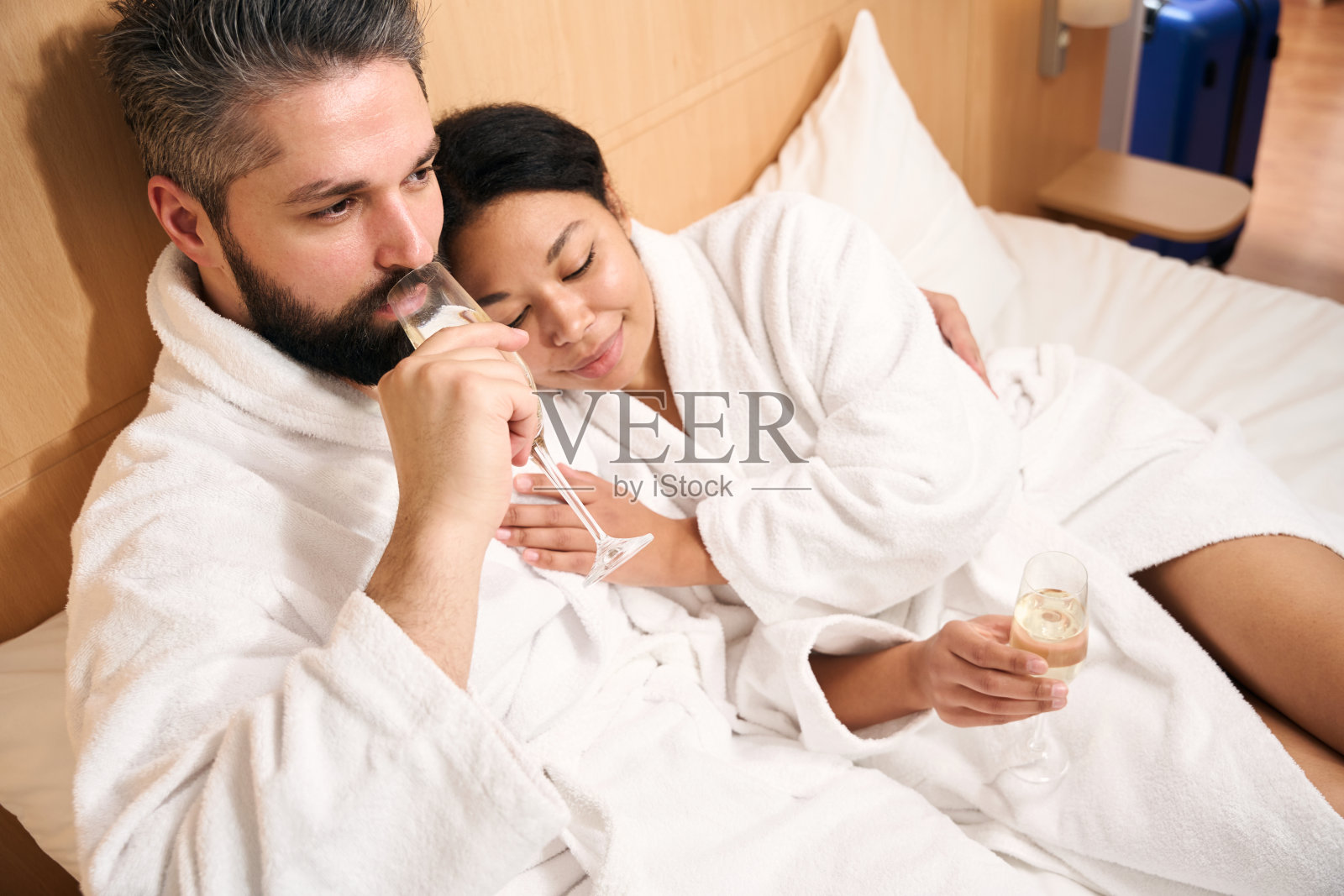 一对穿着浴袍的情侣在酒店房间休息照片摄影图片