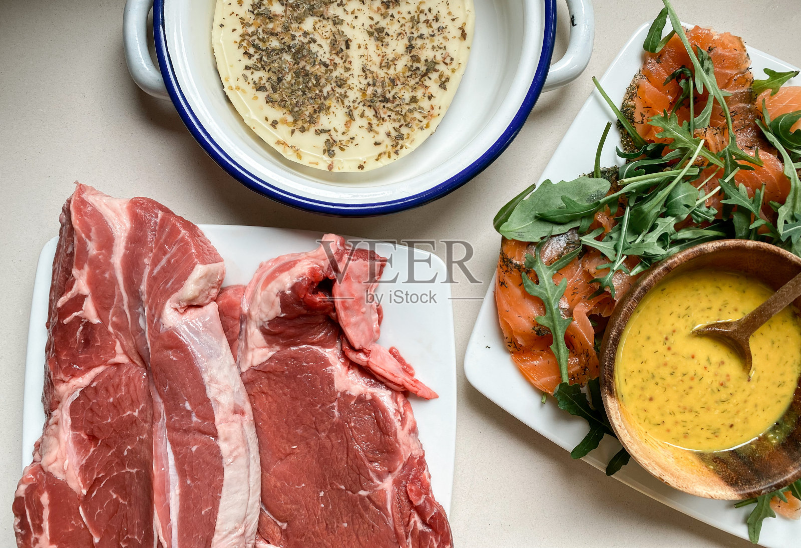 餐桌上有三文鱼盘,准备烤的肉和波洛伏洛干酪照片摄影图片