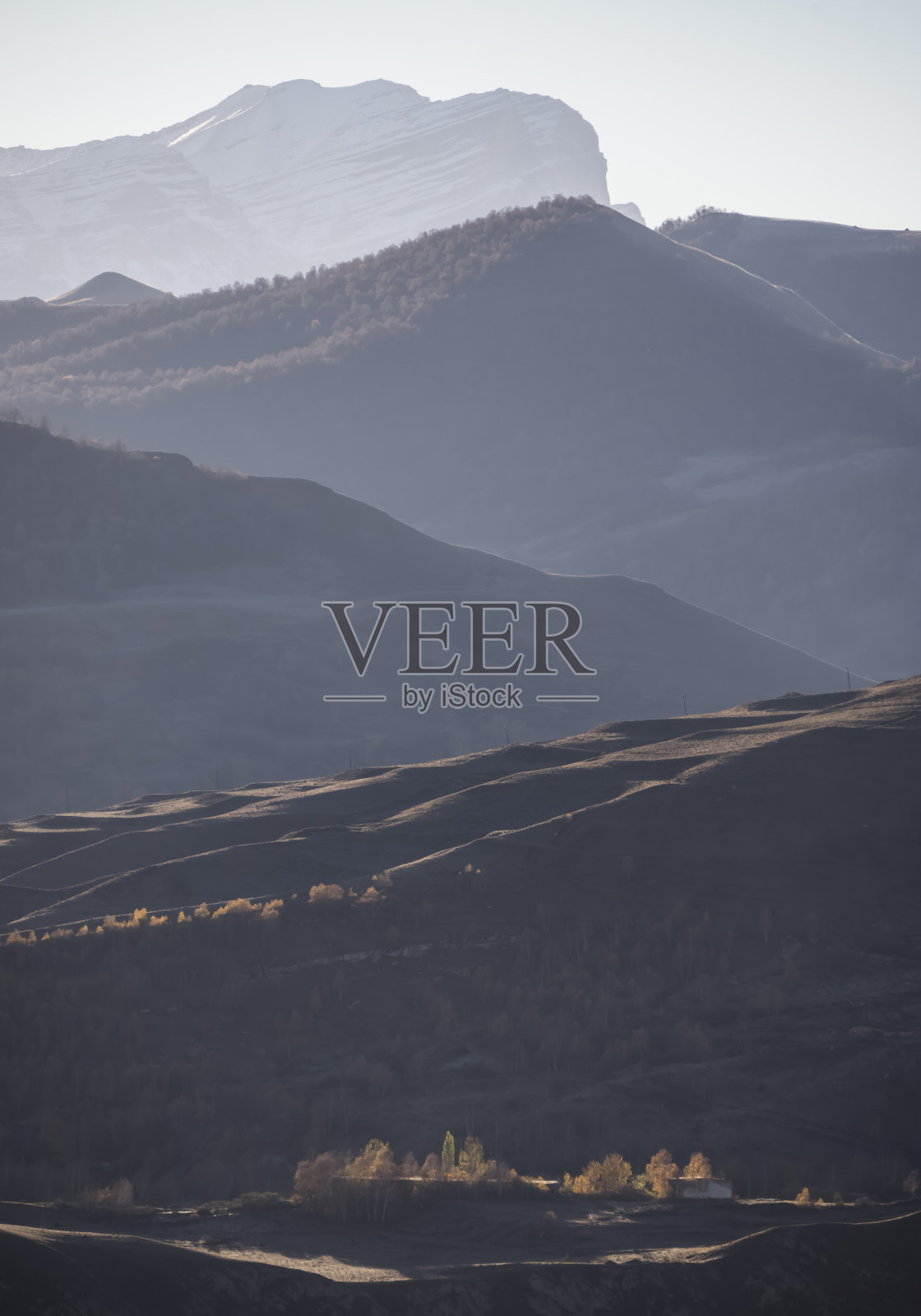 秋日清晨的山坡和山峰全景,明亮的阳光背光,山脉的色调透视照片摄影图片