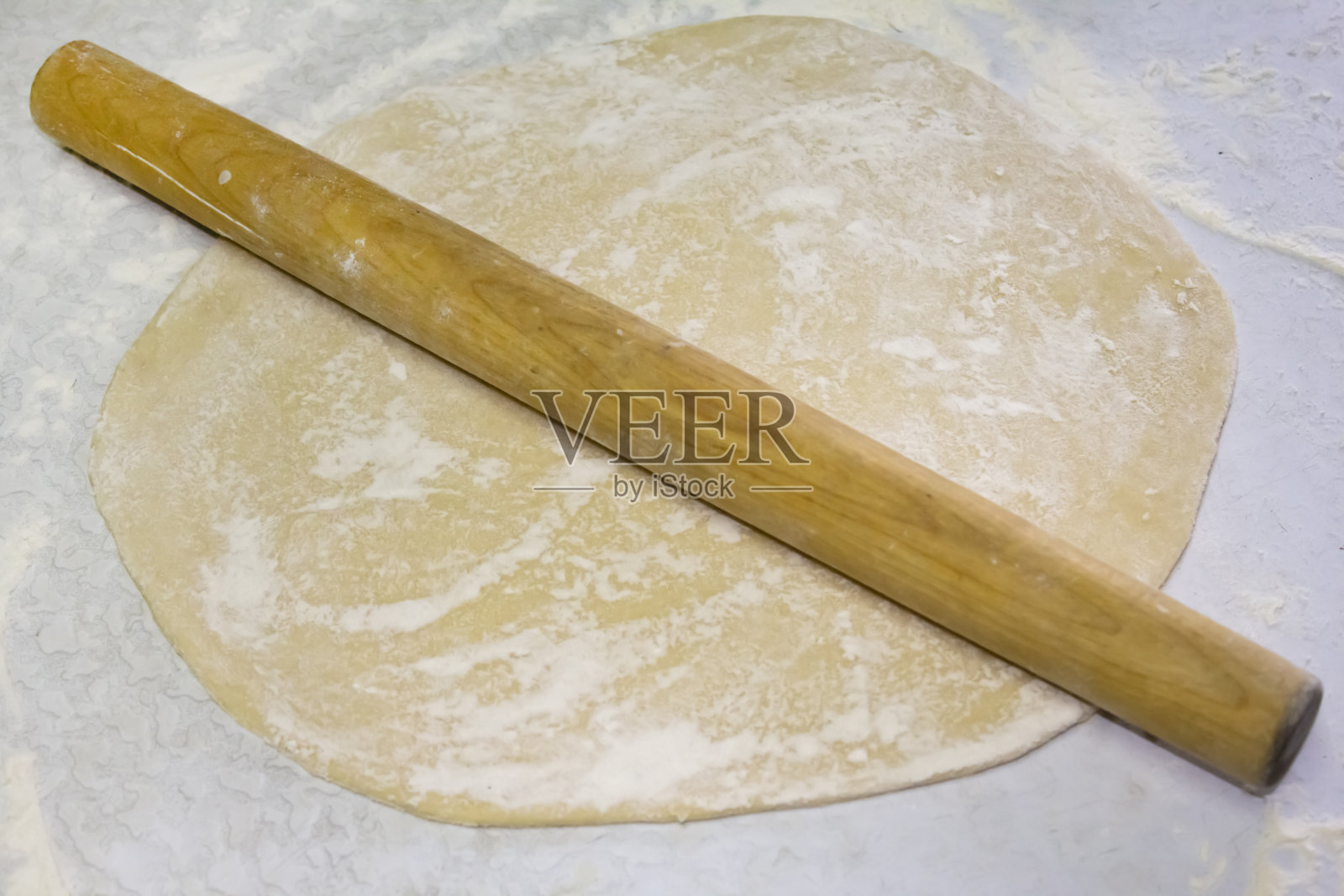 用擀面杖擀出面团。照片摄影图片