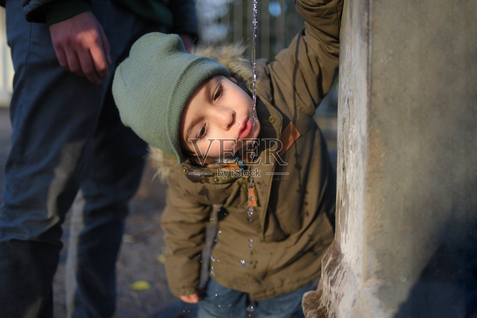 男孩喝自来水照片摄影图片