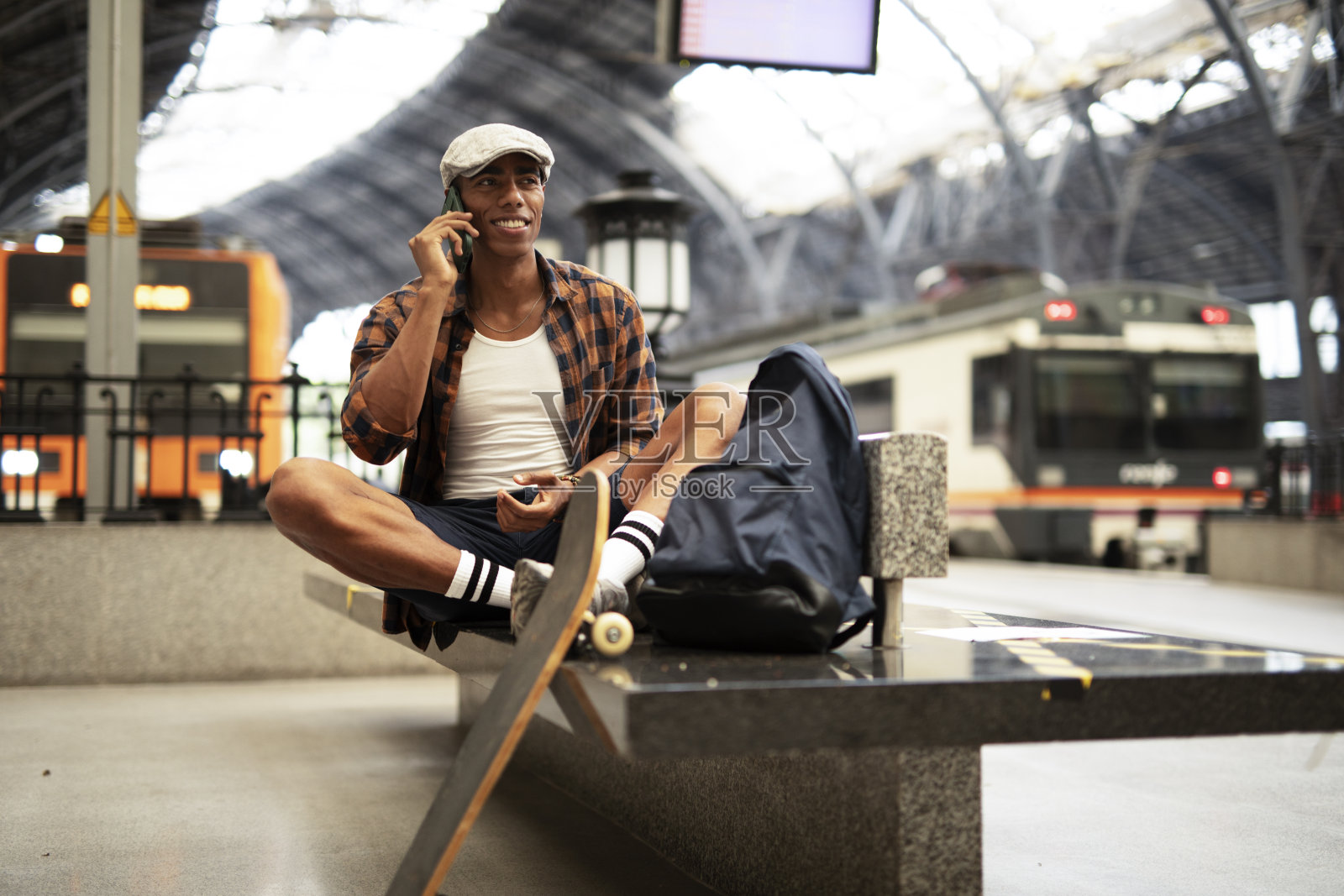 快乐的年轻人在等火车。照片摄影图片