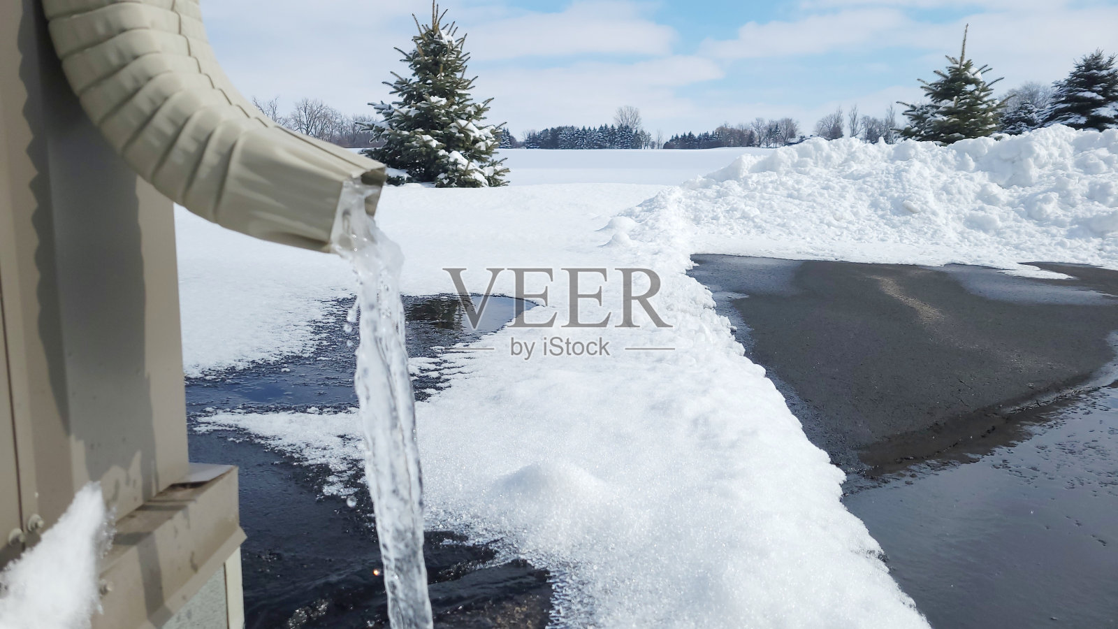 在阳光明媚的冬日里,水管里滴着冰,照片摄影图片