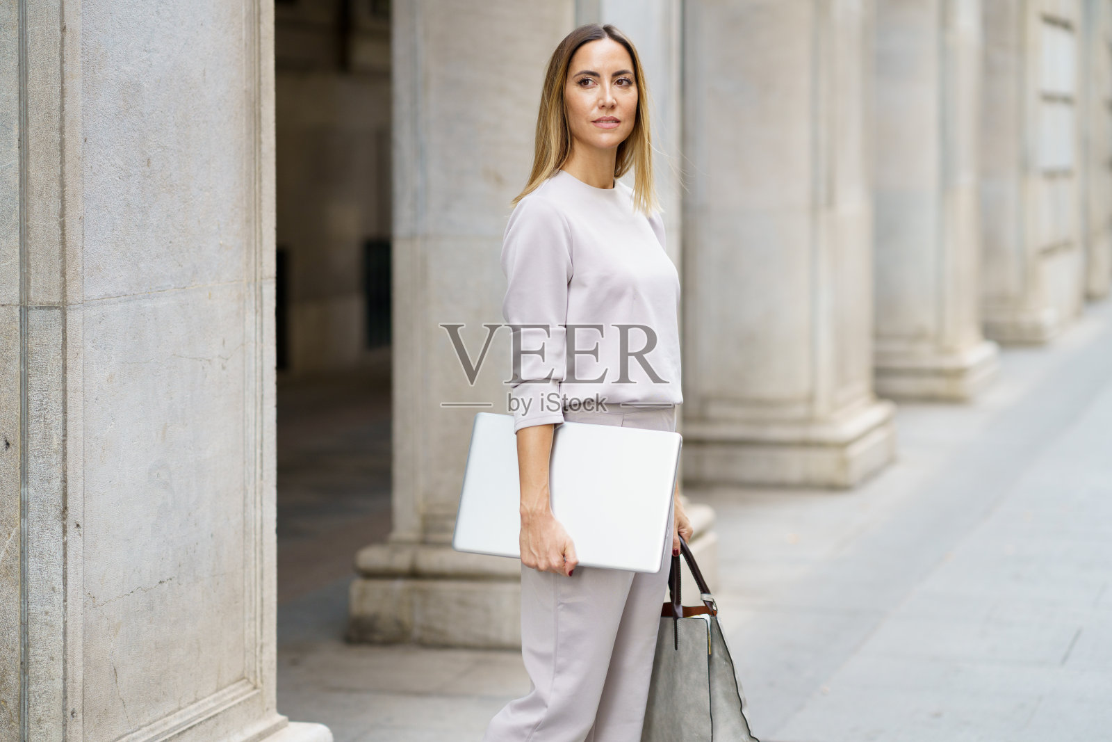 自信的女商人与笔记本电脑在街上照片摄影图片