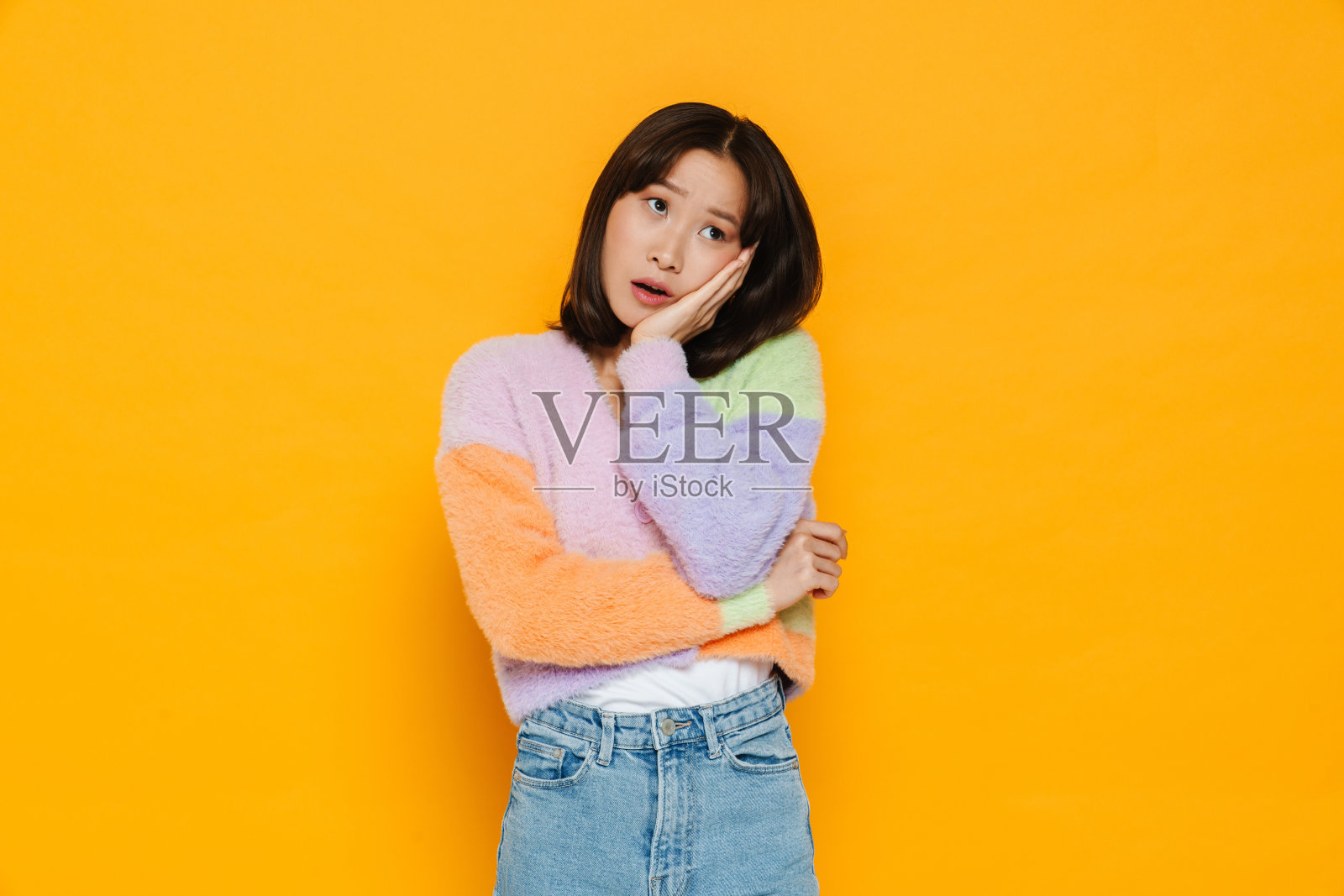 亚洲困惑的女人摆姿势,同时支撑着她的头照片摄影图片