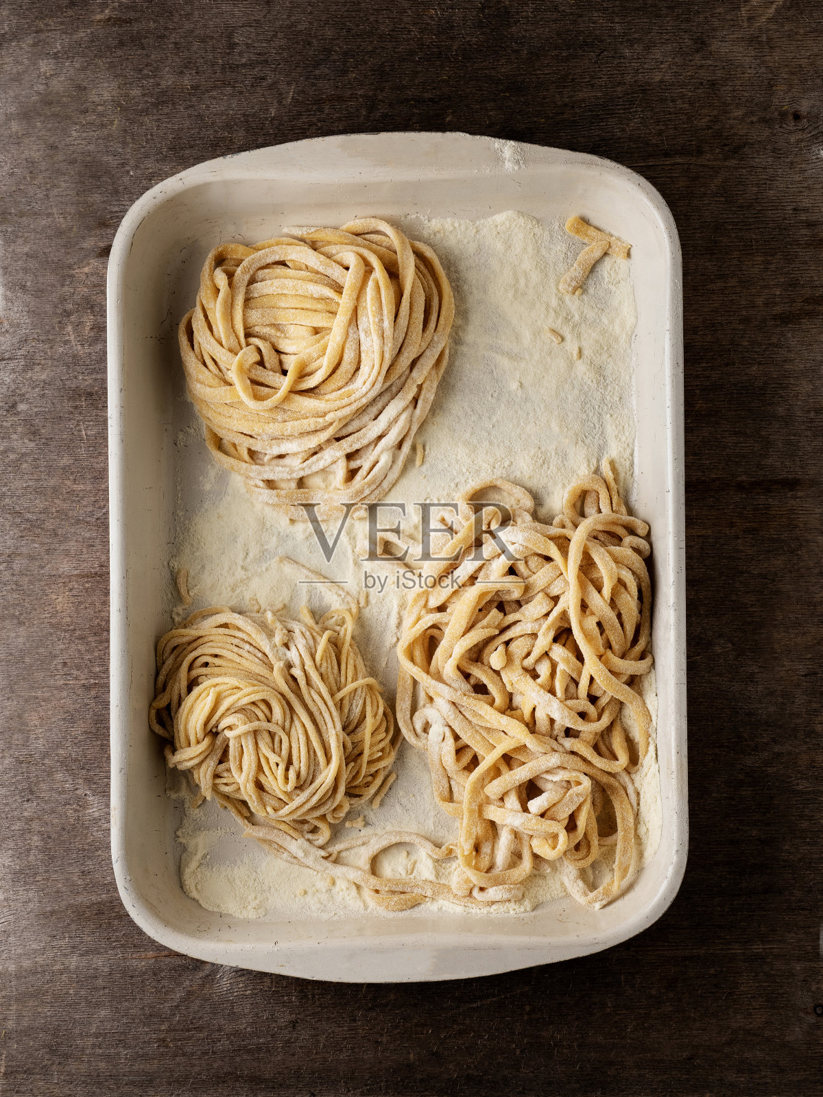 新鲜的意大利传统意面,新鲜的生生意面,意大利扁面条,意大利面巢,意大利通心粉,意大利通心粉,生扁面条通心粉巢照片摄影图片