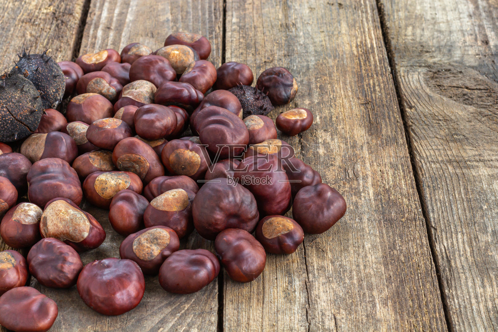 烤栗子放在灰色的质朴木桌上。照片摄影图片