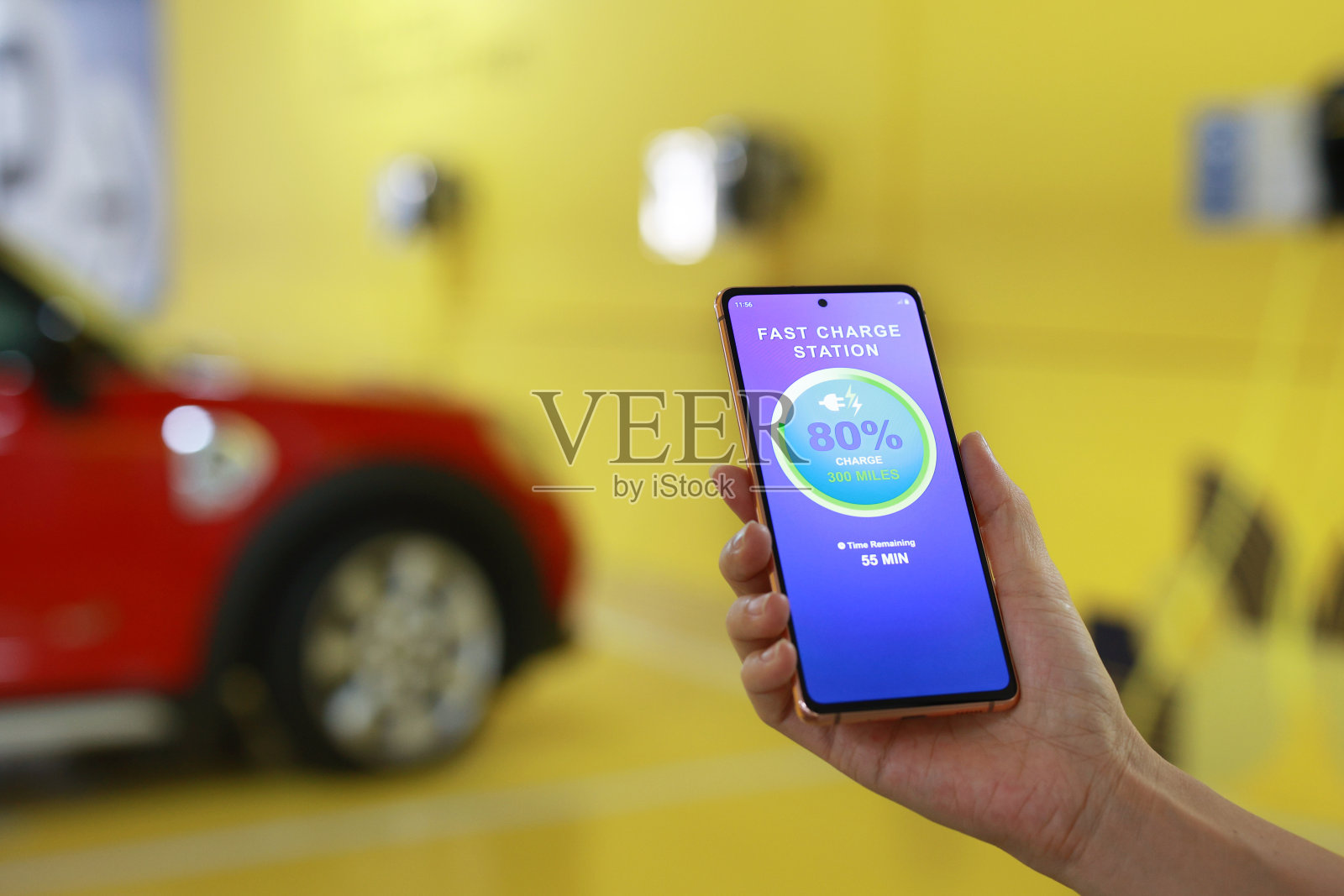 一名女子用智能手机查看她的电动汽车充电状态的特写镜头照片摄影图片