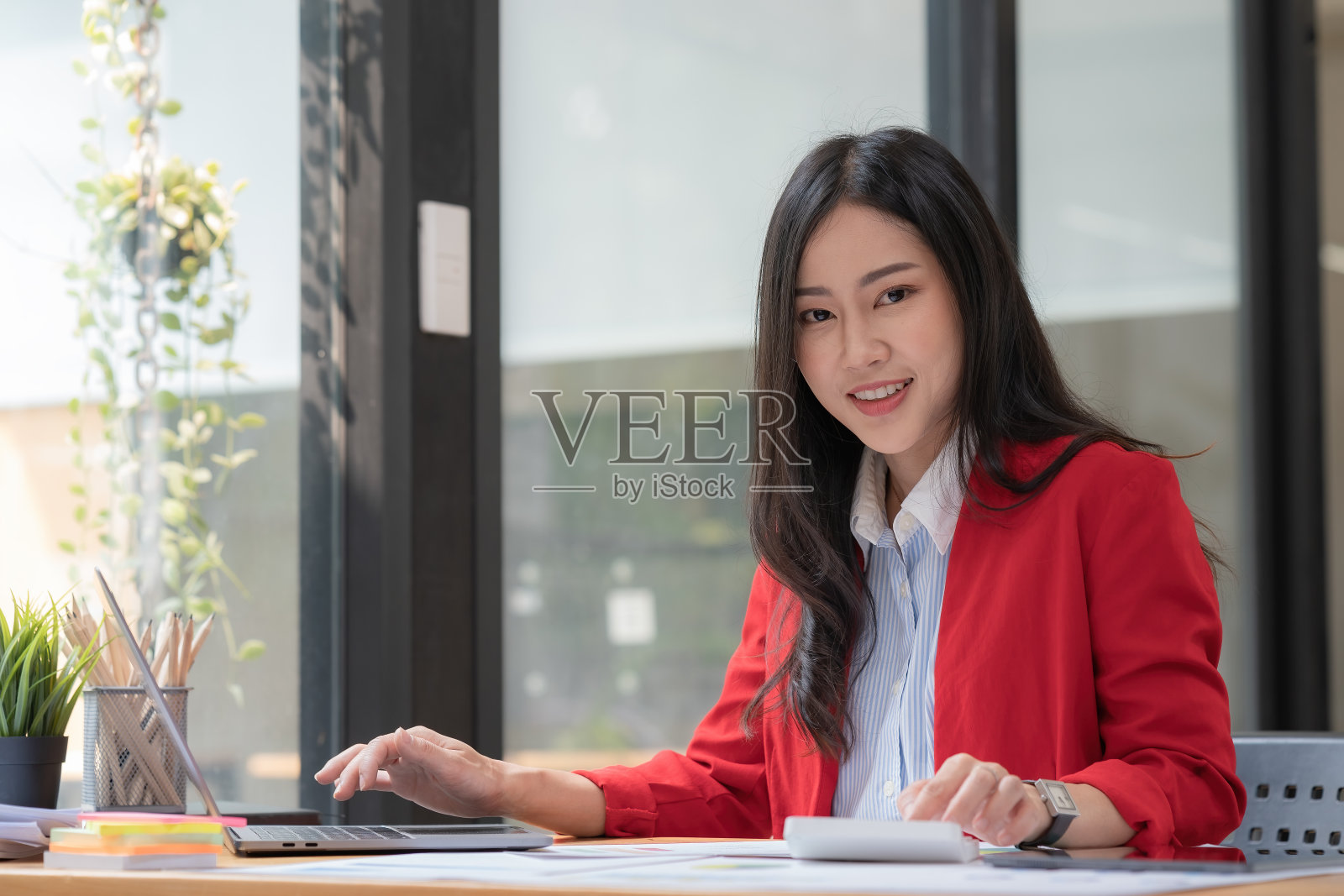 亚洲商业女性使用计算器和笔记本电脑在办公桌上做数学、金融、税务、报告、会计、统计和分析研究概念照片摄影图片