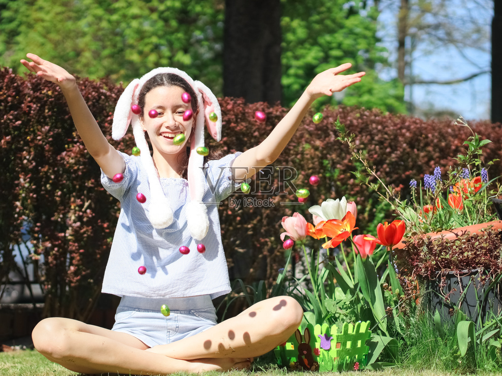 白人少女在草坪上拿着飞舞的复活节彩蛋。照片摄影图片